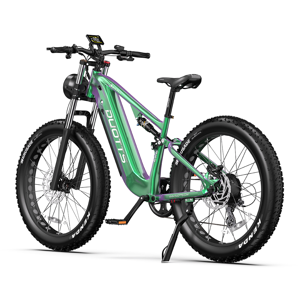 Bicicleta eléctrica verde y morada con neumáticos grandes, fondo blanco y detalles negros.