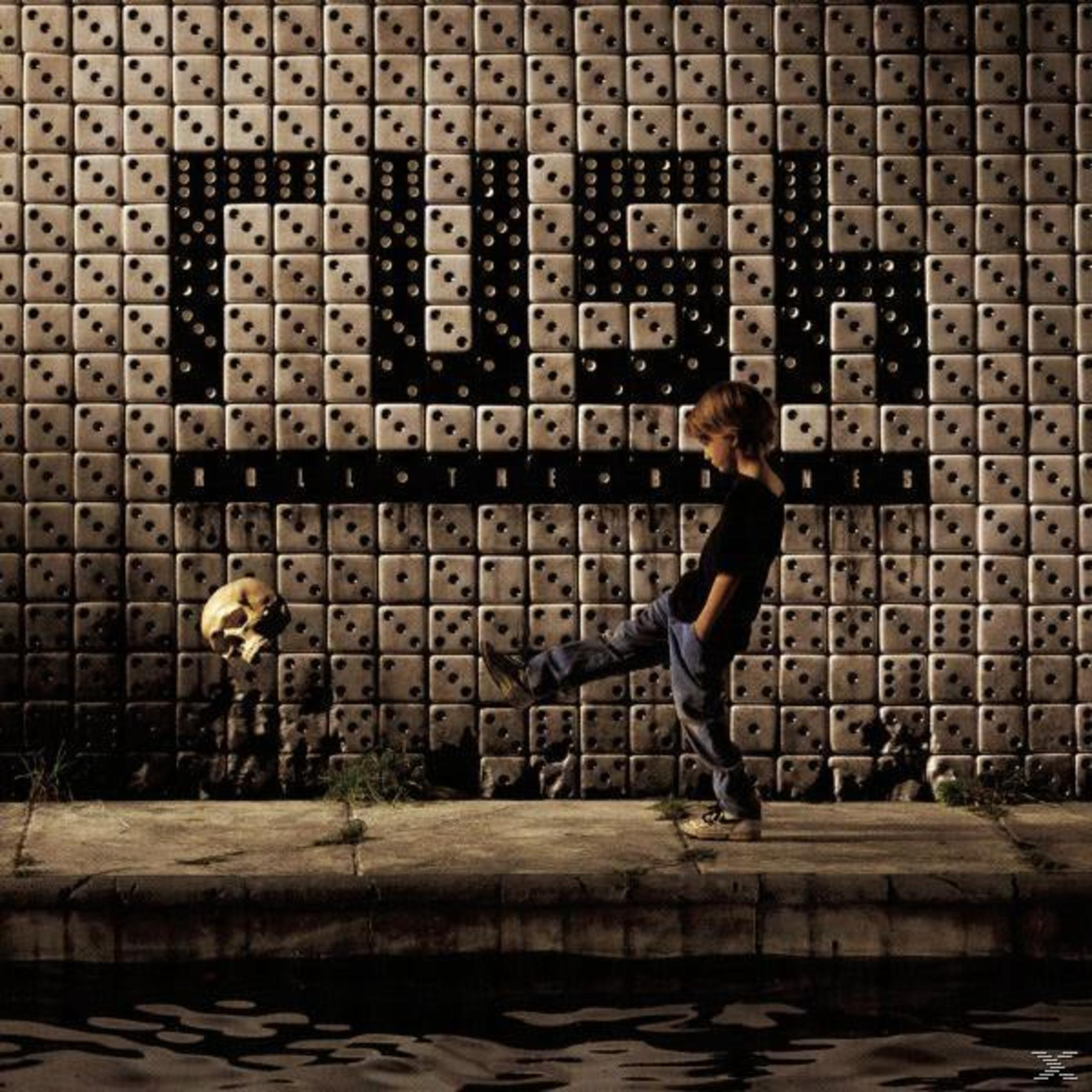 Copertina dell'album con un ragazzo che calcia un teschio su un muro coperto di dadi.