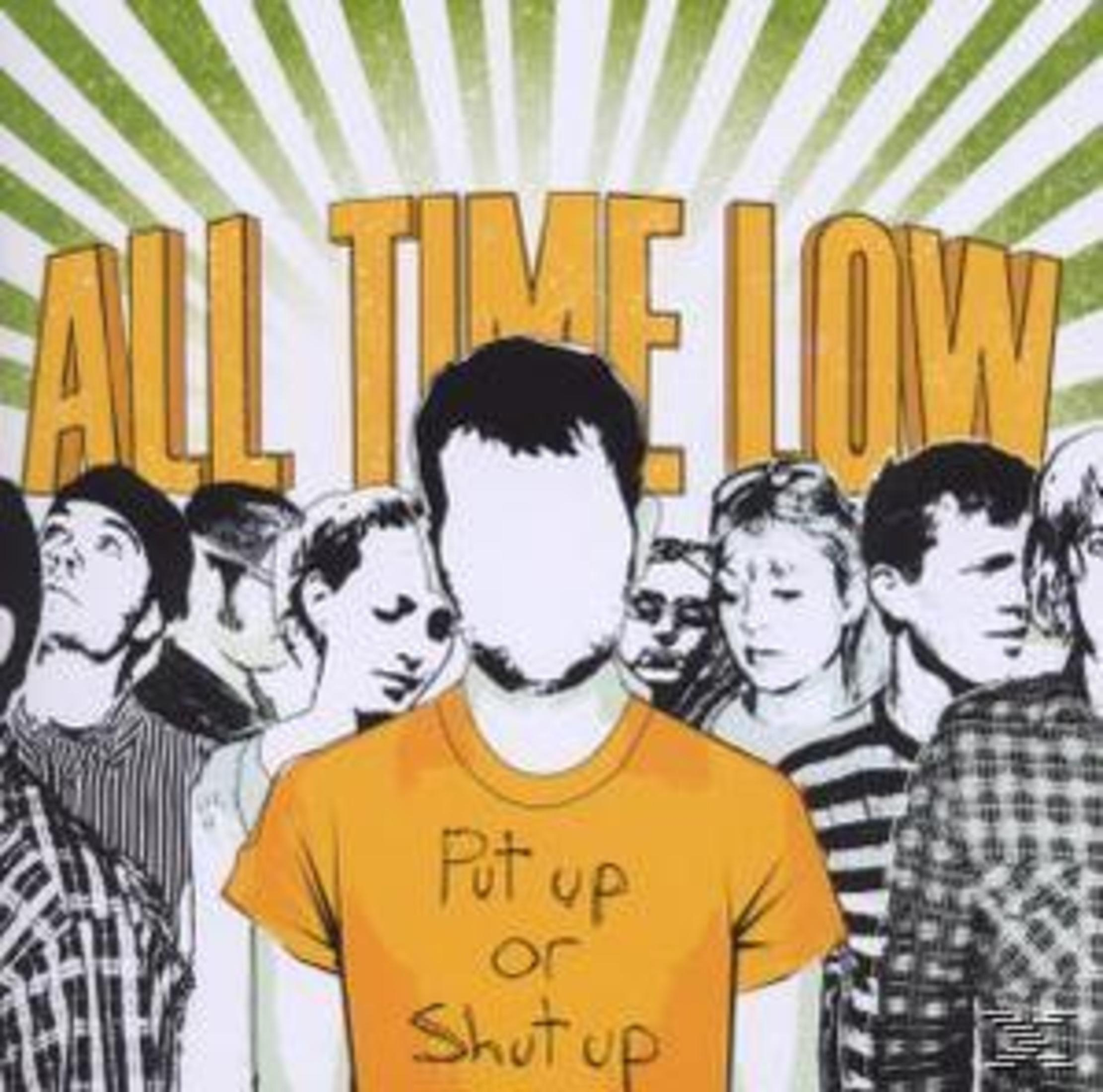 Albumhoes. Een man in een oranje shirt met de woorden 'Put up or Shut up' staat voor een menigte.
