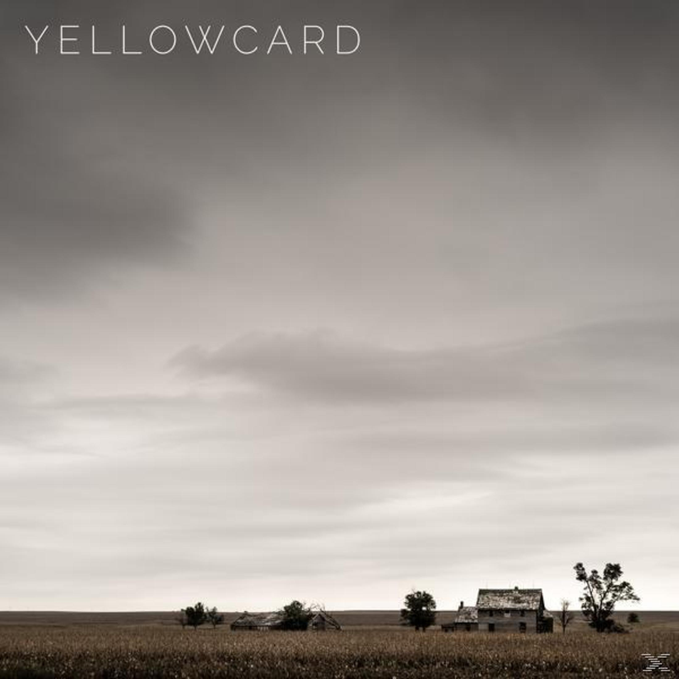 Albumhoes: Yellowcard, grijswaardenafbeelding van een veld met huizen onder een bewolkte lucht.