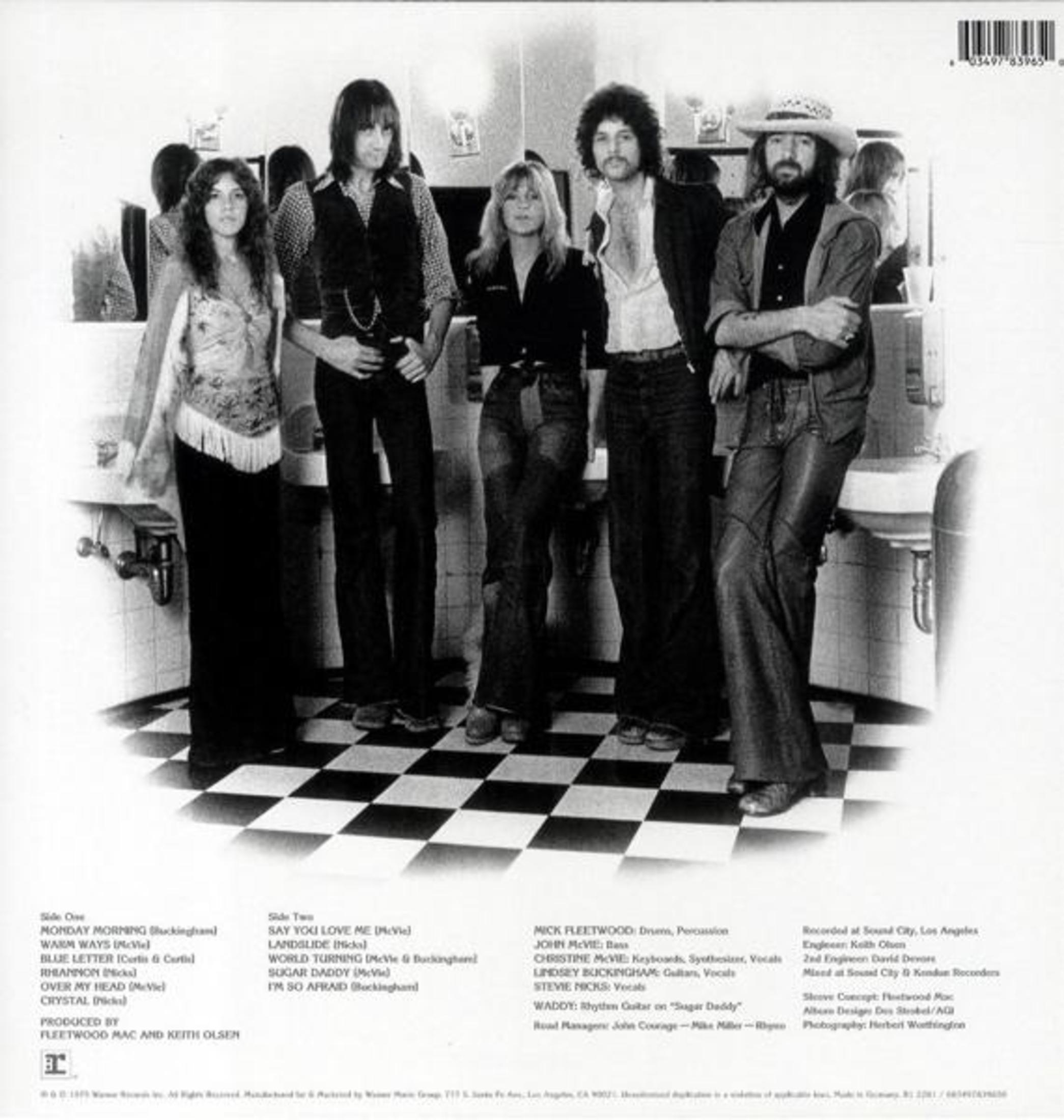 Foto della band Fleetwood Mac. Sei persone di fronte a un muro a specchio, membri della band in vari abiti.