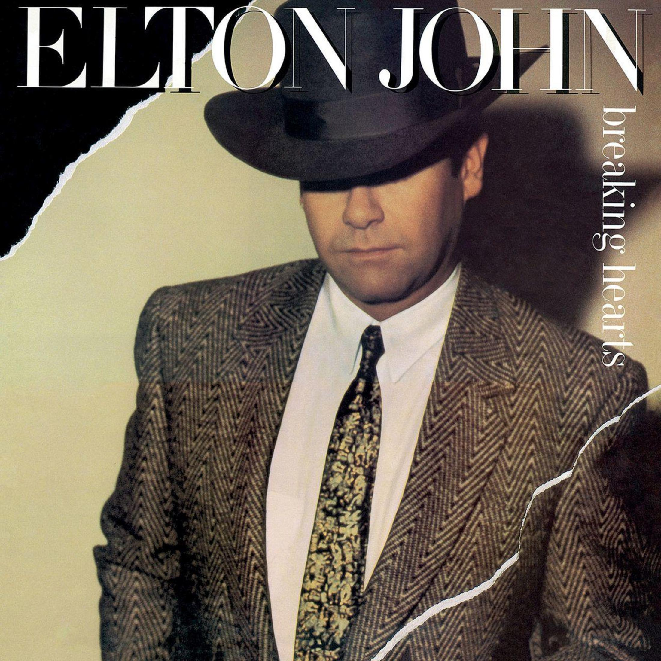 Albumhoes van Elton John, met een pak, hoed en stropdas. De albumtitel is "Breaking Hearts".