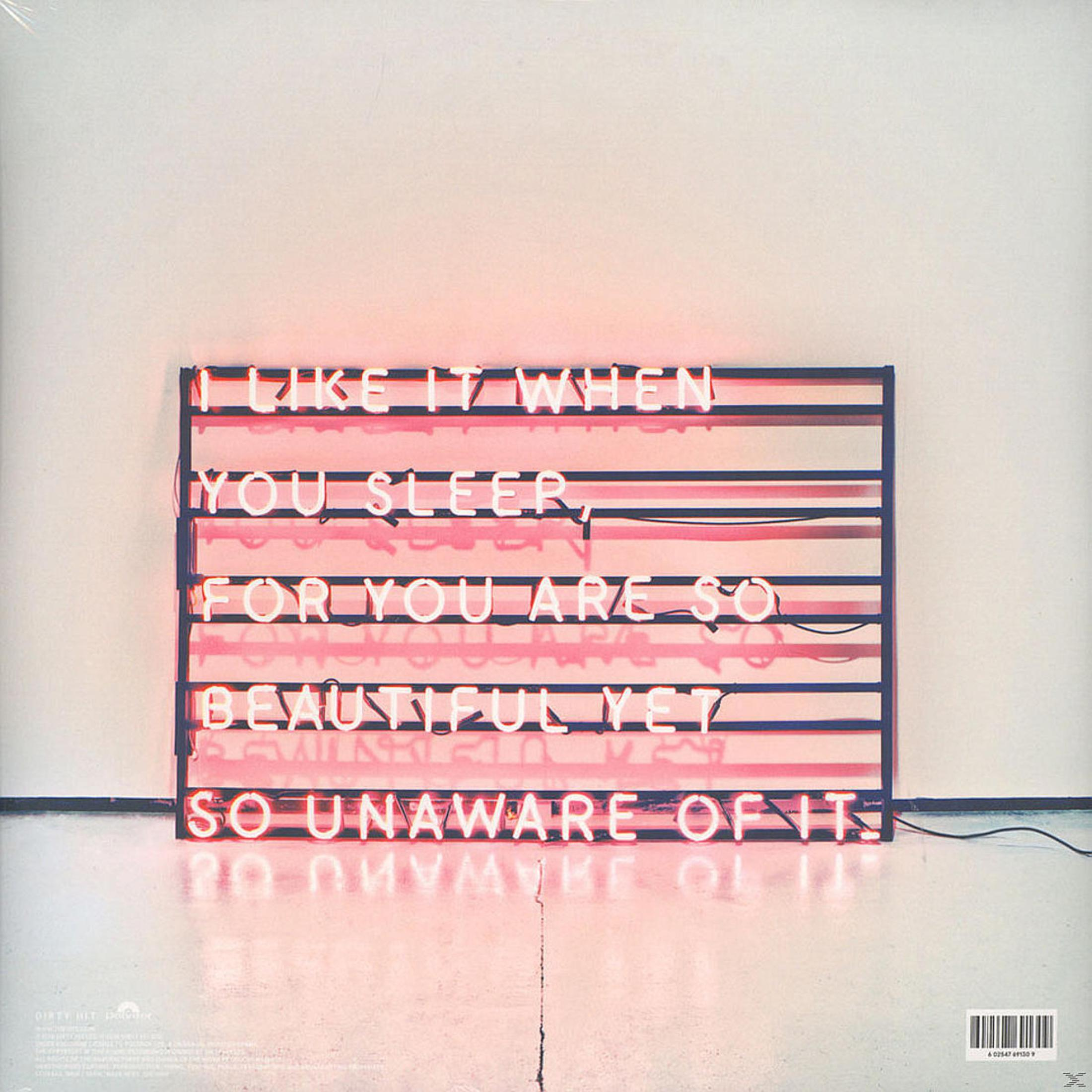 Insegna al neon con le parole, 'I like it when you sleep...'. Neon rosa contro un muro bianco.