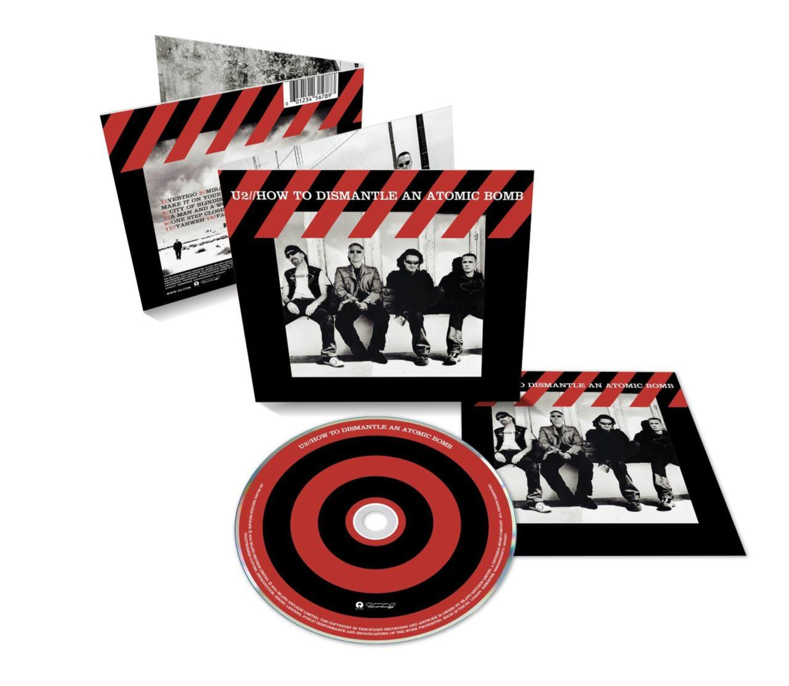 Portada del álbum U2 con miembros de la banda, CD e inserciones, tema negro y rojo.