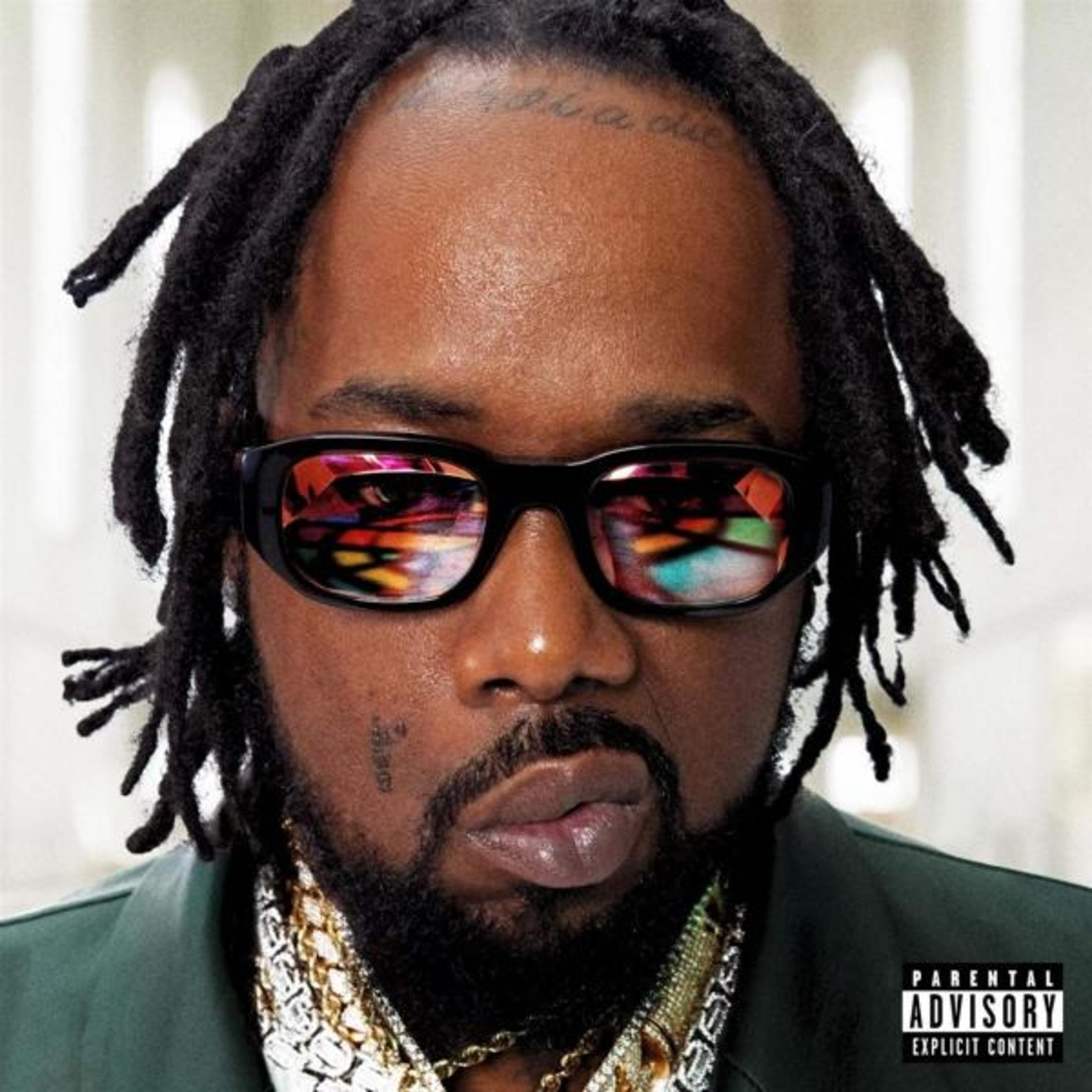 Un uomo con occhiali da sole, con espressione seria, copertina dell'album. Catene d'oro, dreadlocks.