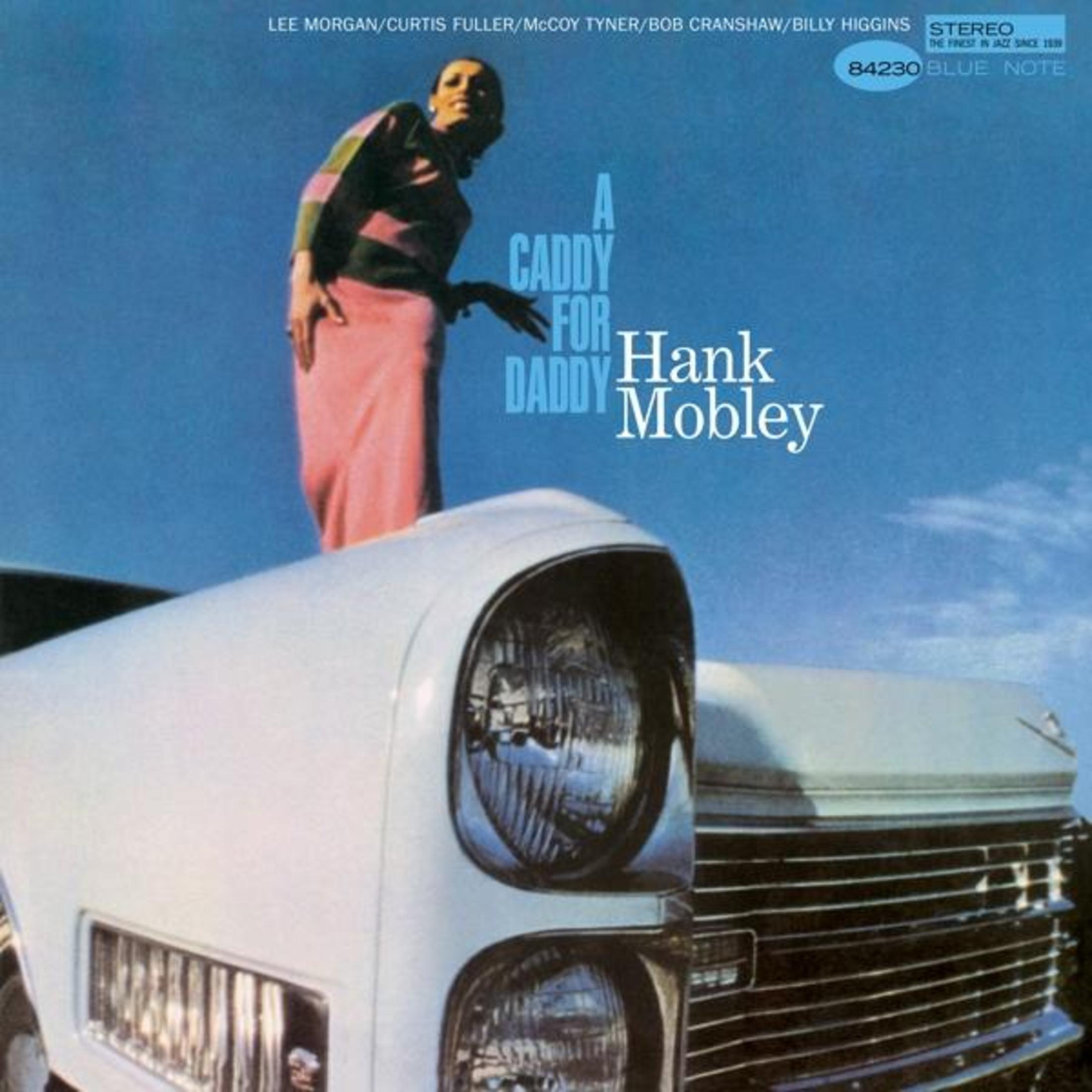 Copertina dell'album: Uomo in abito rosa, in piedi davanti a un'auto bianca.