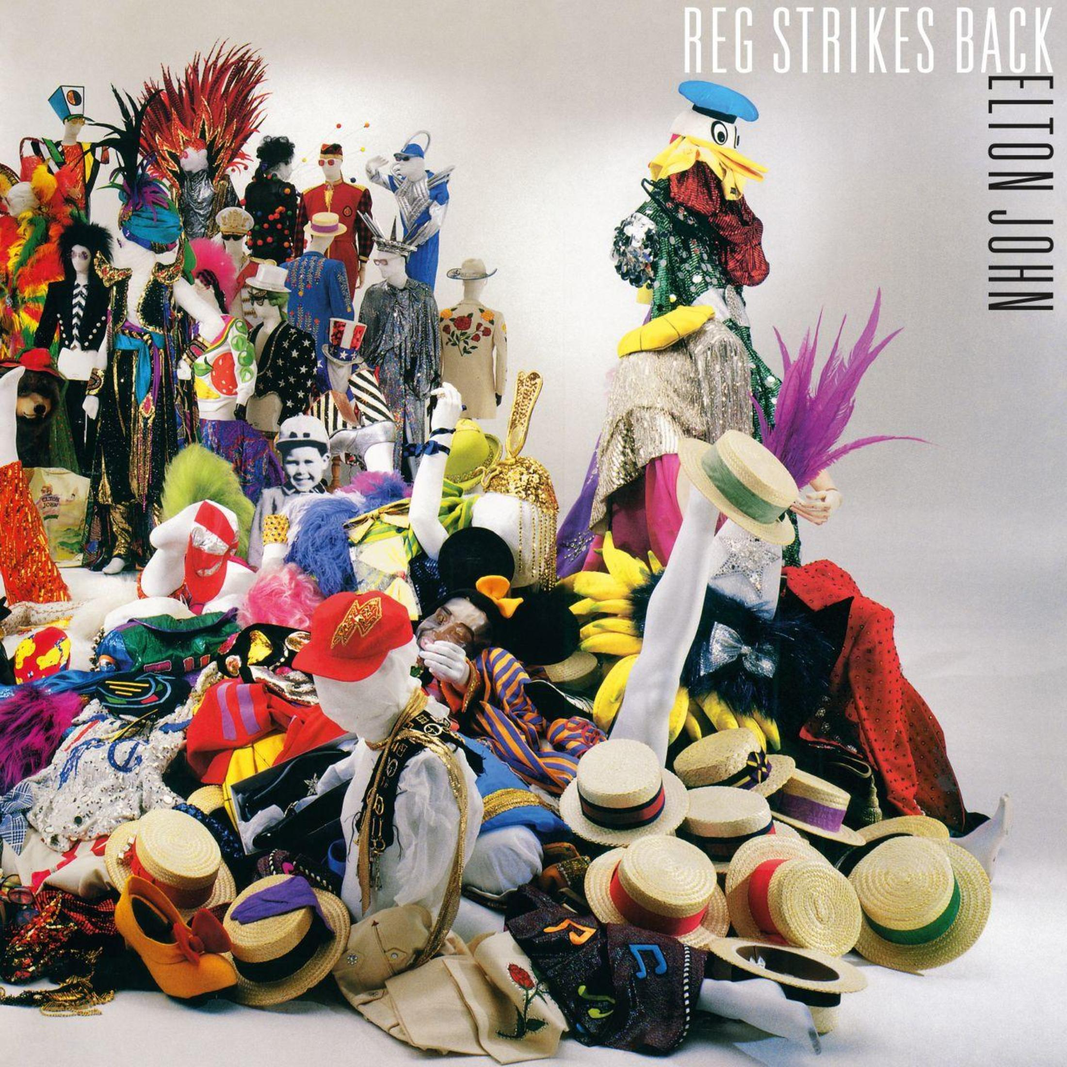 Copertina dell'album di Elton John. Vari costumi e accessori sono esposti su sfondo bianco.