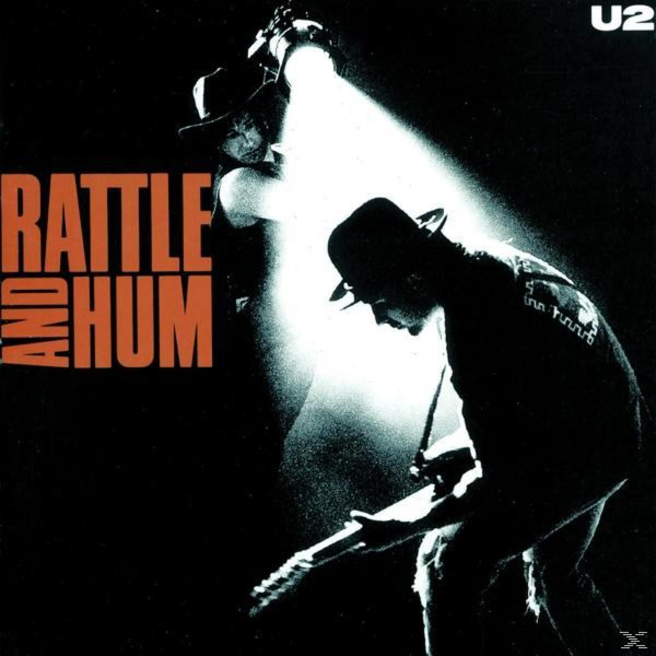 Copertina dell'album degli U2, sfondo nero, due figure in silhouette con cappelli, una suona la chitarra, titolo: Rattle and Hum.