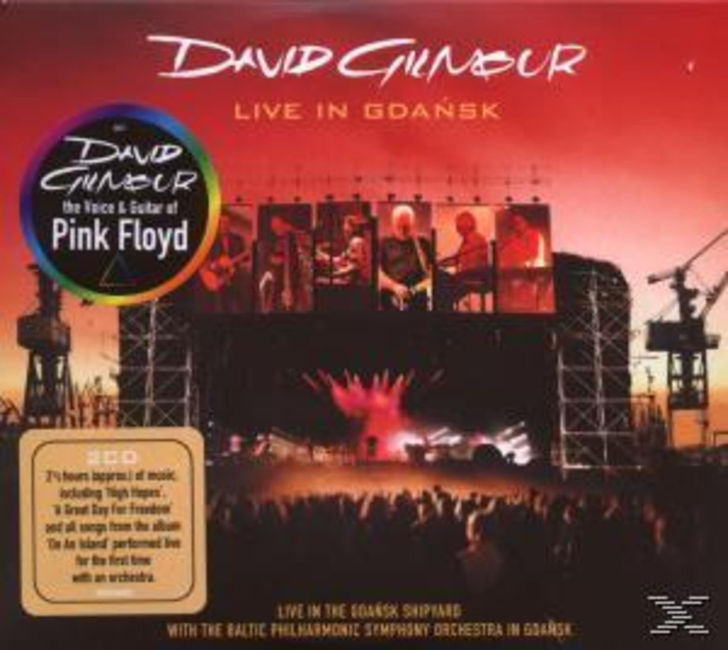 CD-hoes: David Gilmour Live in Gdańsk. Een podiumscène met bandleden en publiek.