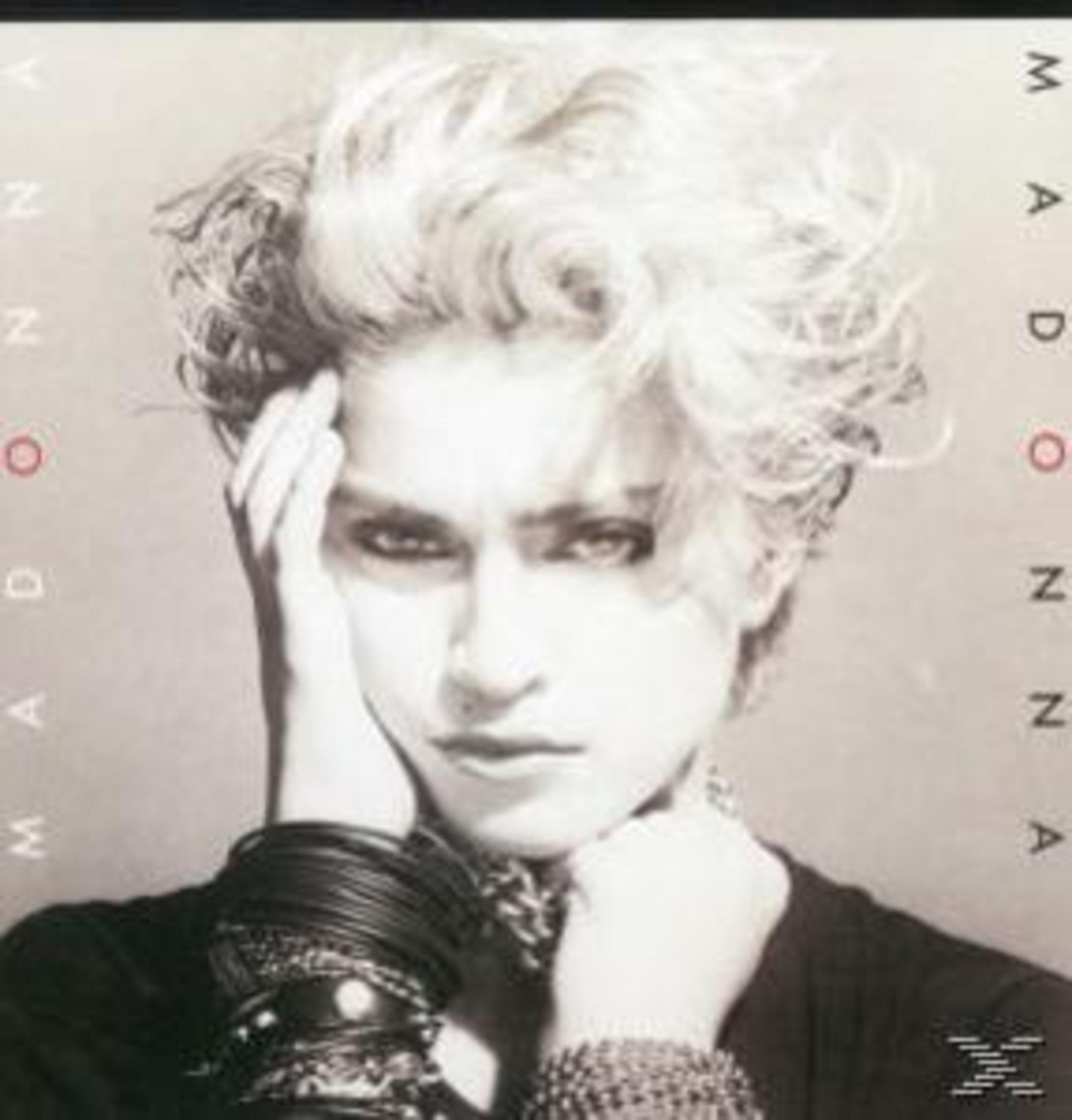 Copertina dell'album di Madonna: Ritratto in bianco e nero, capelli biondi, mani vicino al viso e il nome 'Madonna'.