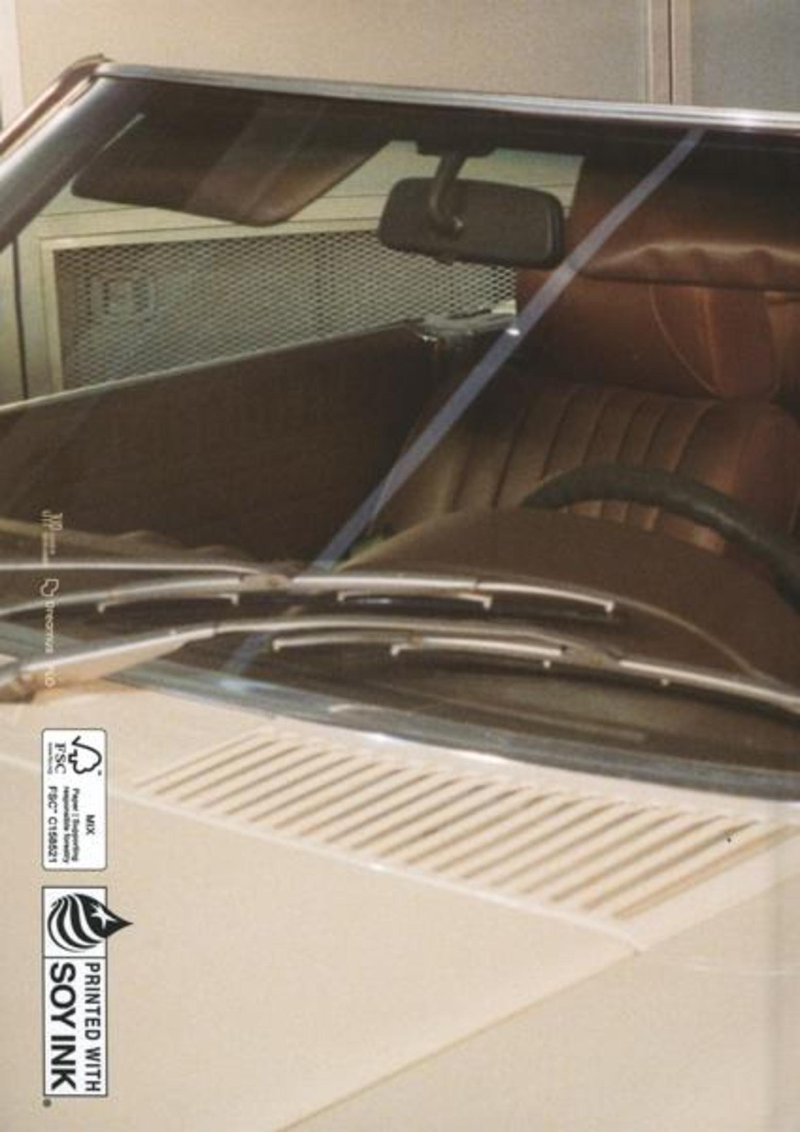 Car interior view: Windshield, dashboard, steering wheel, brown seats. Light beige exterior.
