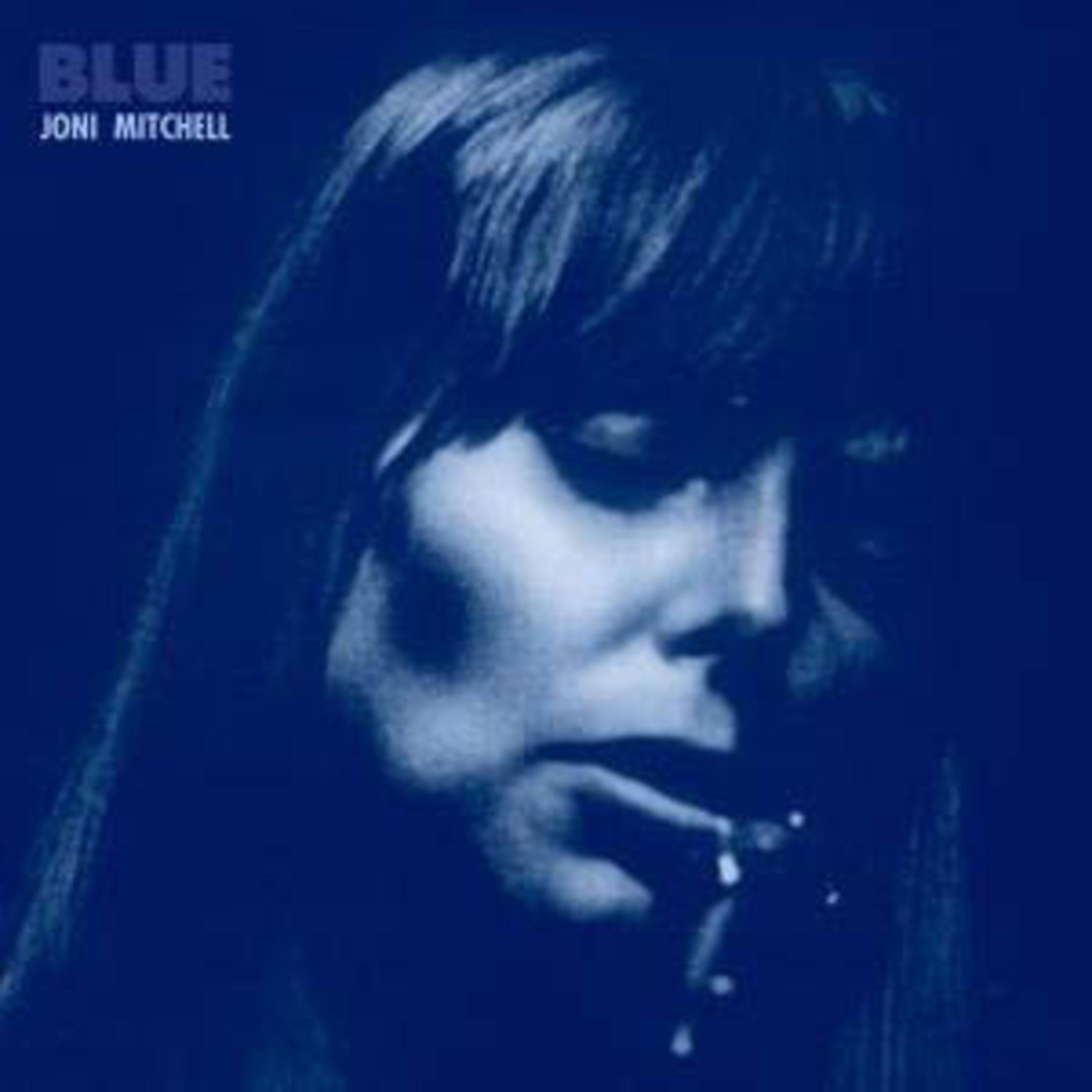 Il volto di Joni Mitchell su una copertina blu. Sta guardando in basso, fumando una sigaretta.