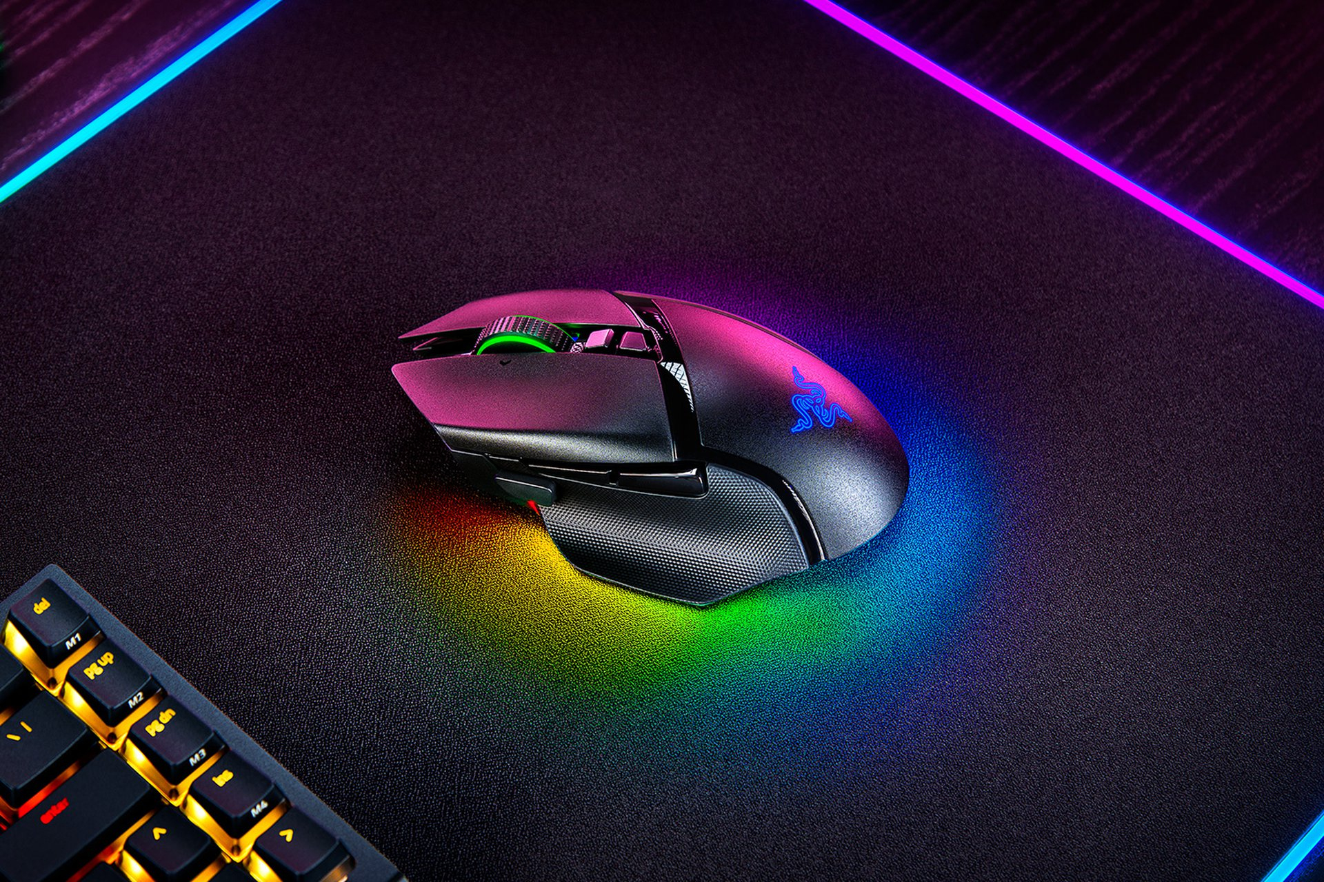 Czarna mysz gamingowa Razer na czarnej powierzchni z kolorowym oświetleniem RGB na krawędziach.