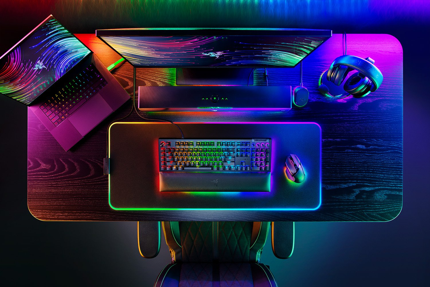 Configurazione di gioco con computer, monitor, tastiera, mouse e cuffie. La stanza è buia con luci colorate.