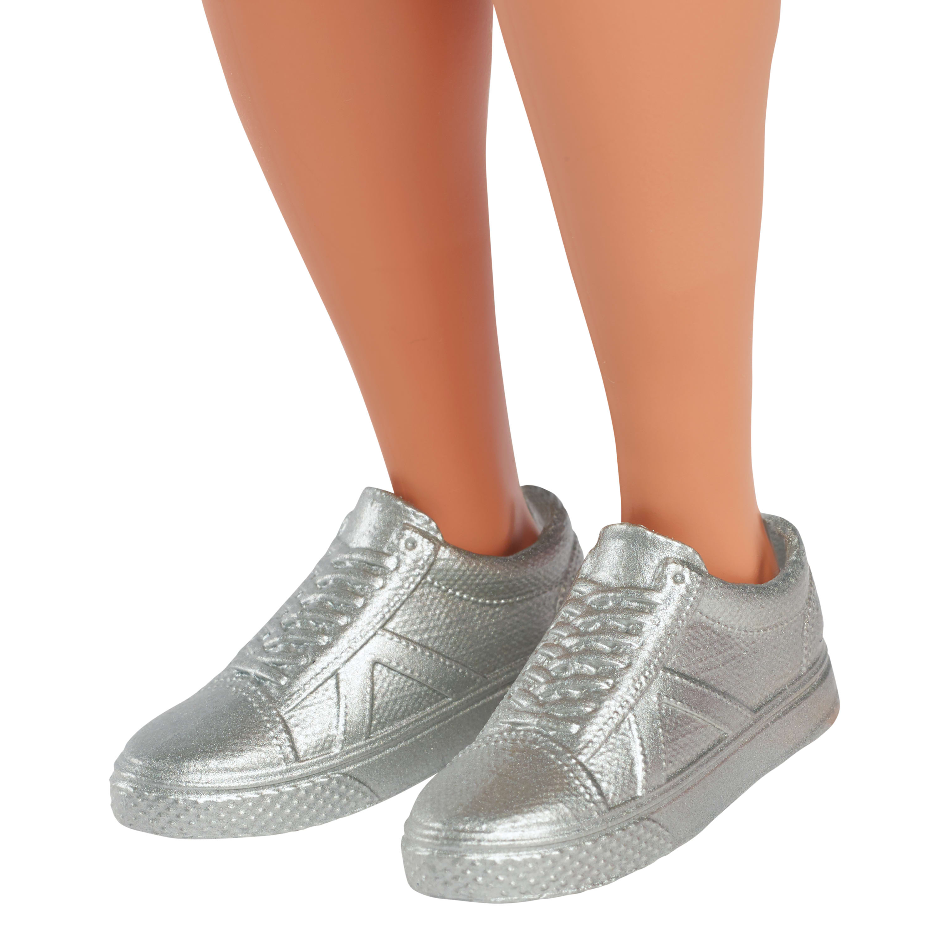 Srebrne trampki na jasnej skórze nóg. Buty mają sznurowadła i błyszczące wykończenie.