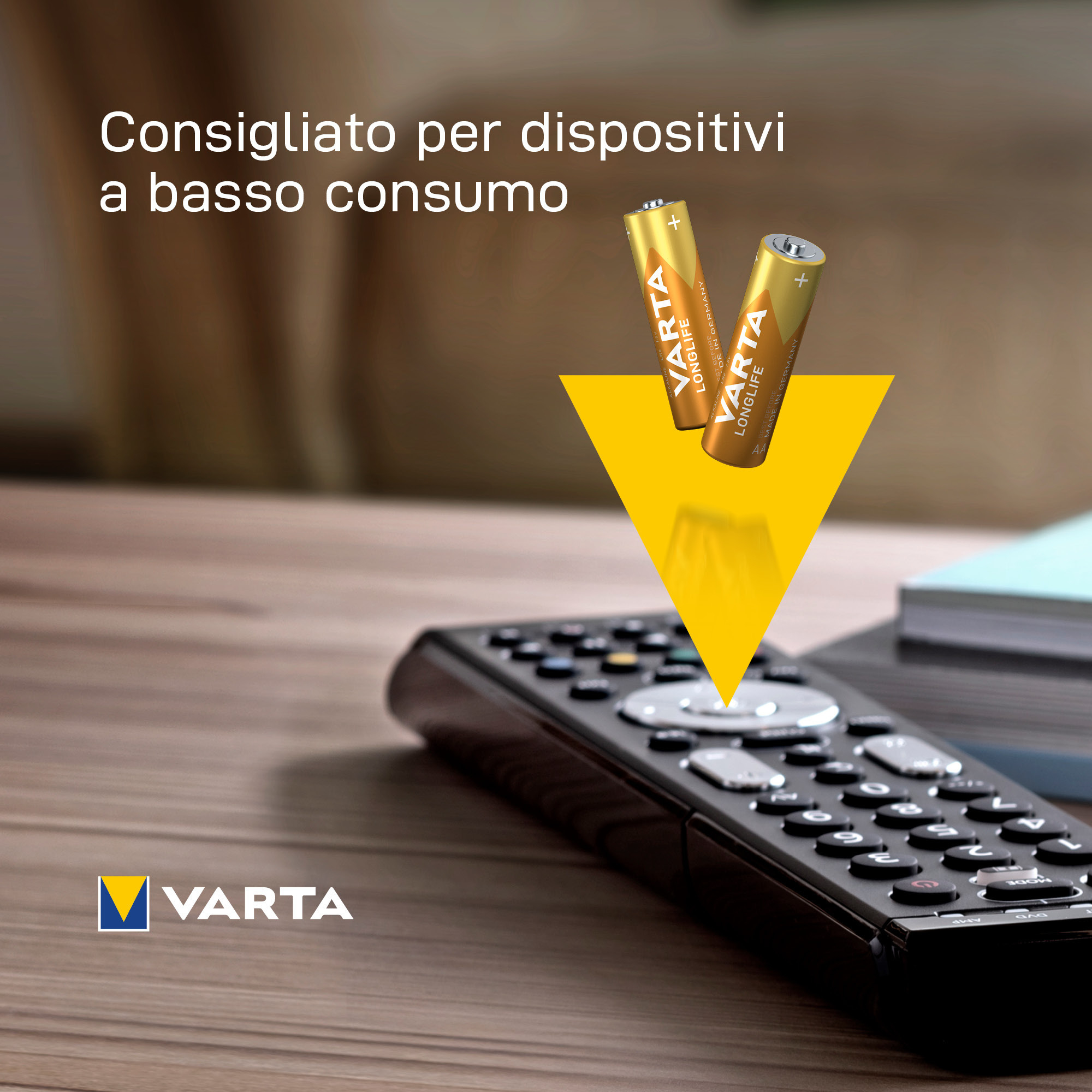 Two gold AA batteries, in front of a remote, with text indicating use for low consumption devices.