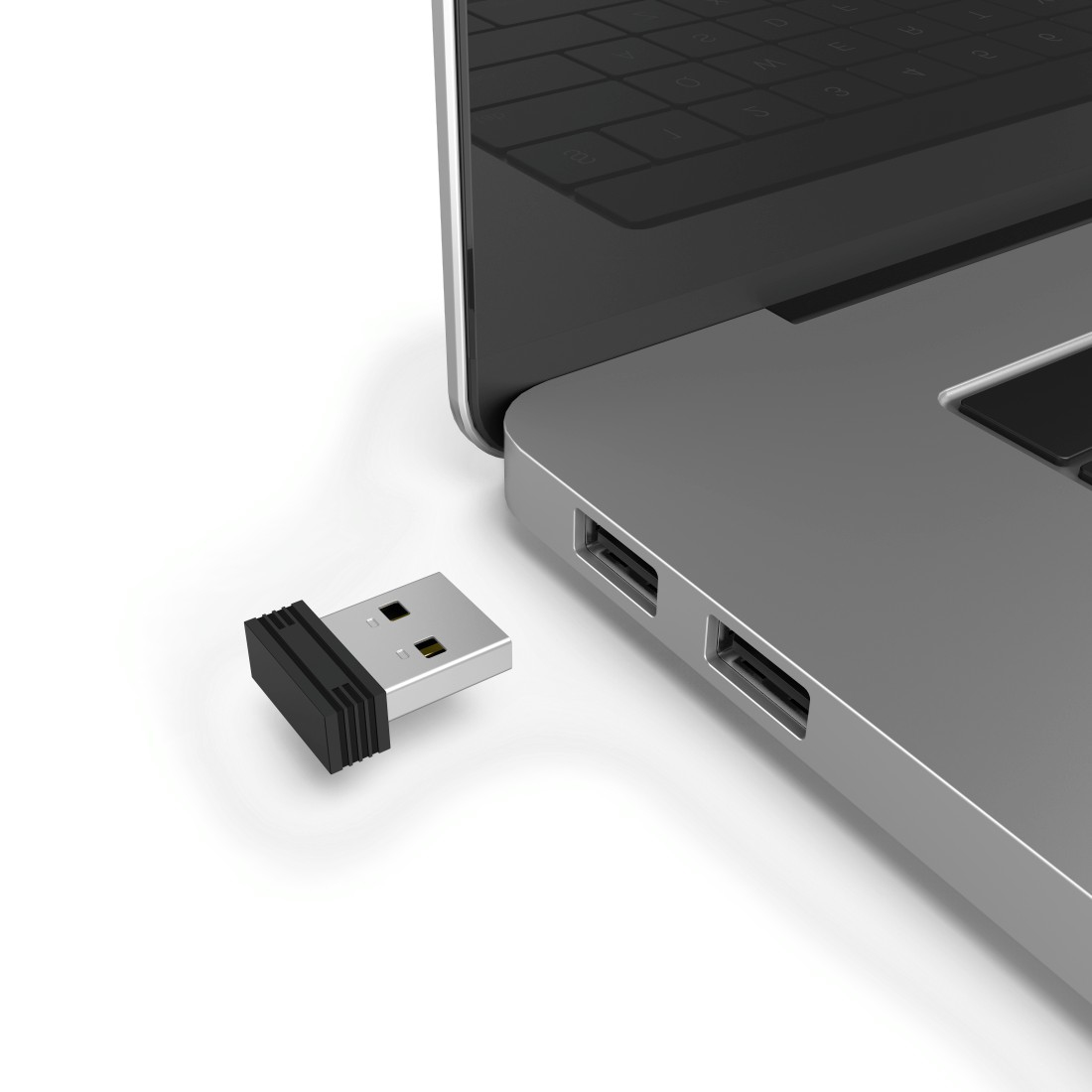 Ein USB-Empfänger in der Nähe eines Laptops mit sichtbaren USB-Anschlüssen.
