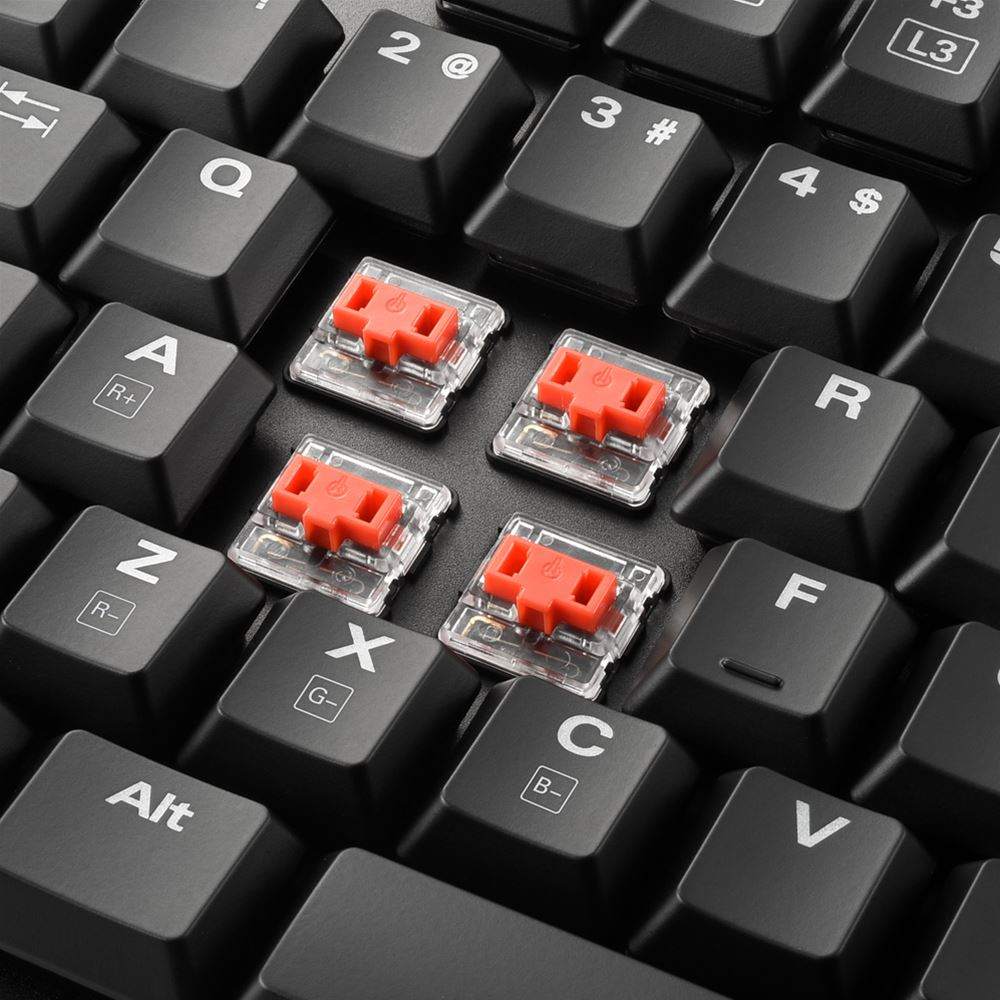Close-up of black keycaps with red mechanical switches.