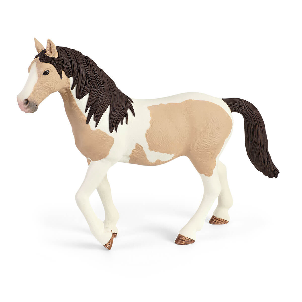 Un cheval jouet avec une robe blanche et marron, debout sur une surface blanche.