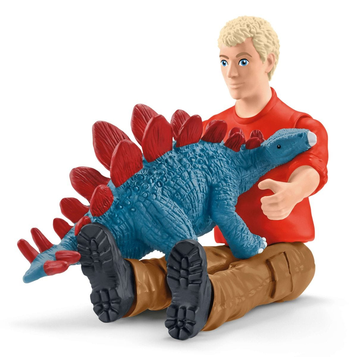 Ein Mann hält ein blaues Dinosaurier-Spielzeug mit roten Stacheln, sitzend, auf weißem Hintergrund.