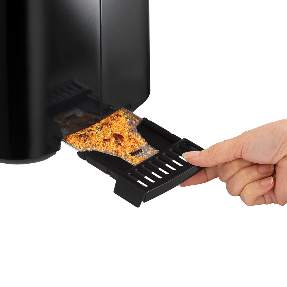 Ręka wyciąga tackę z tostami z czarnego tostera. Chleb jest przypalony.