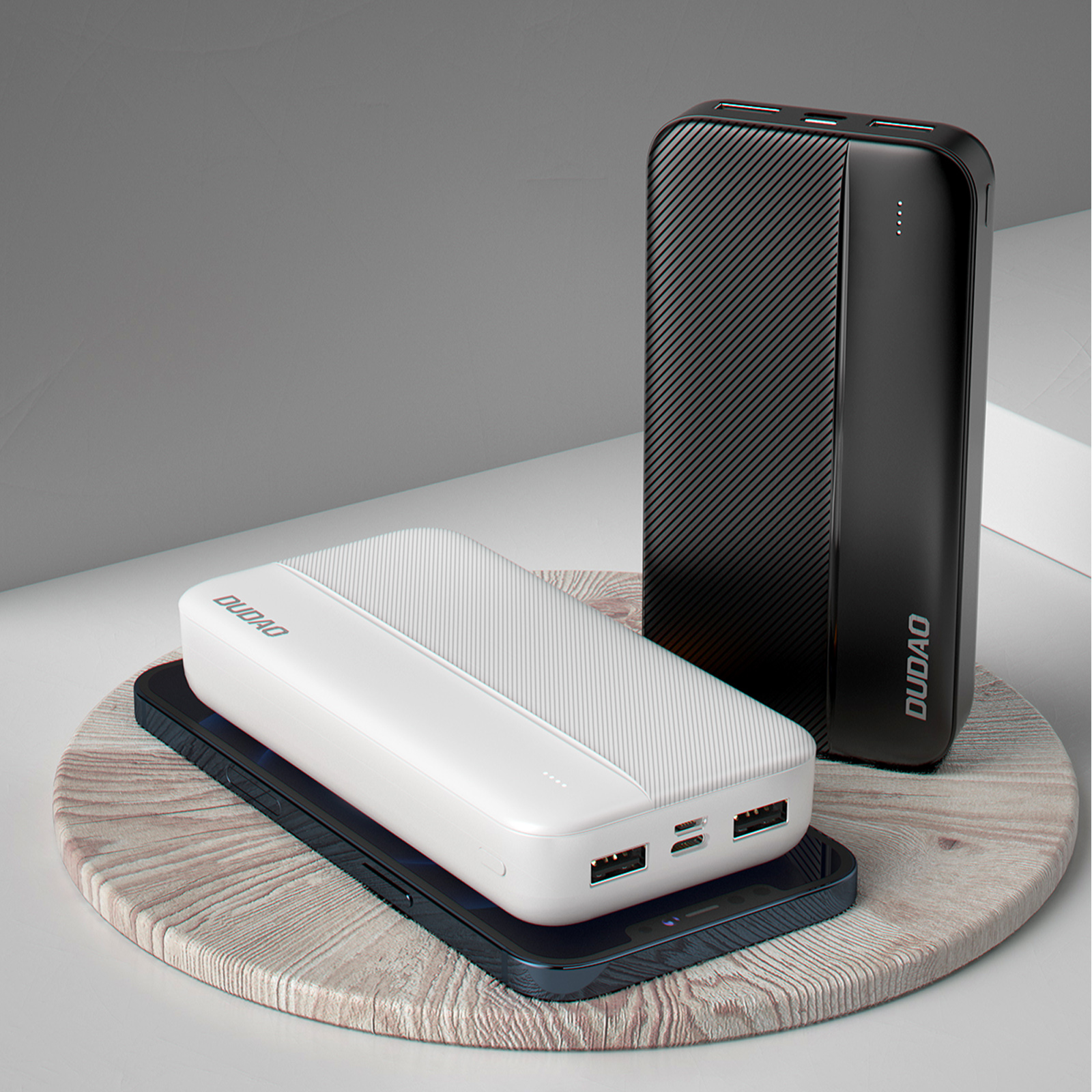 Schwarze und weiße Powerbanks auf einem Holzständer mit einem Mobiltelefon. Moderne Technologie.