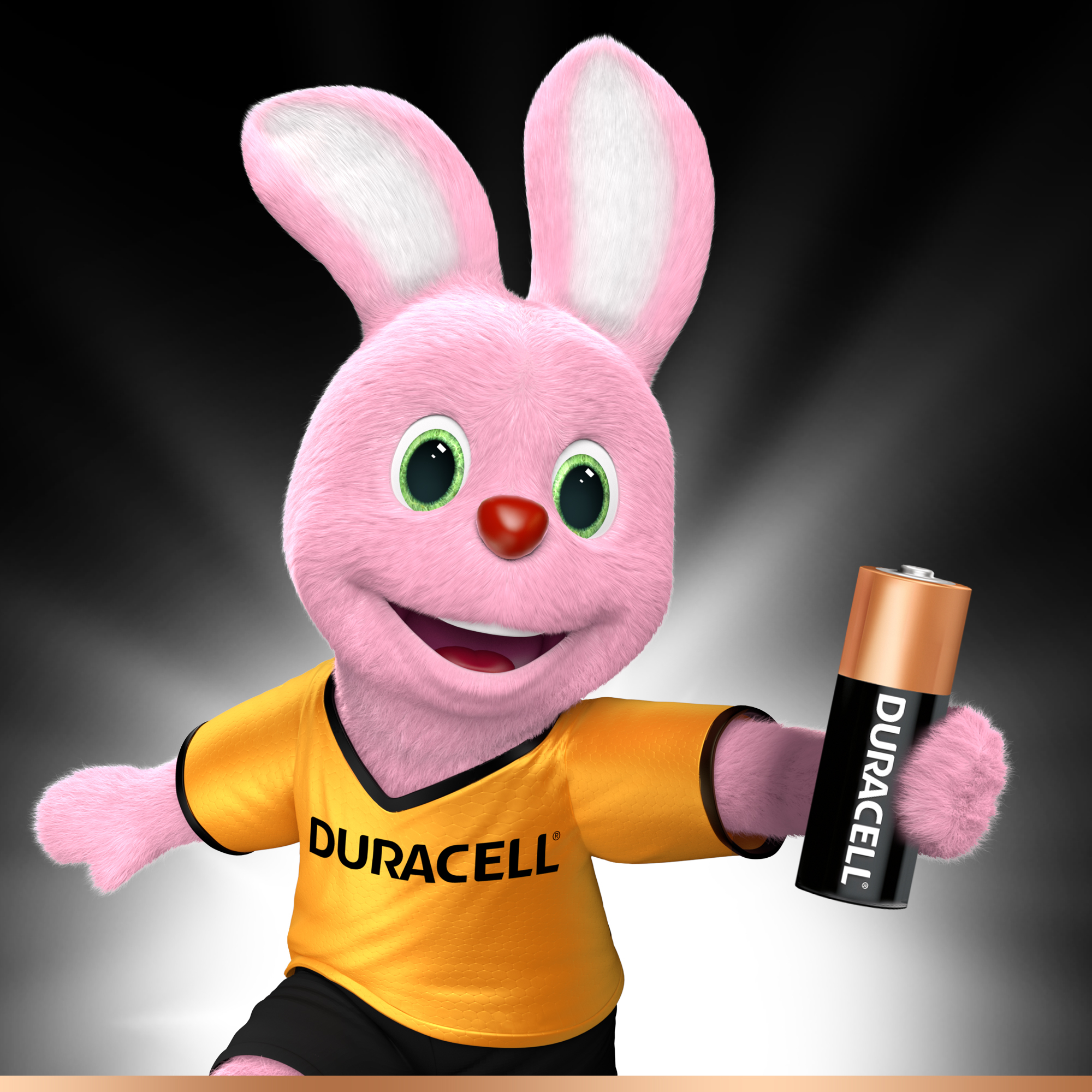 Een roze konijnenmascotte houdt een Duracell-batterij vast. Het konijn draagt een geel shirt met het Duracell-logo.