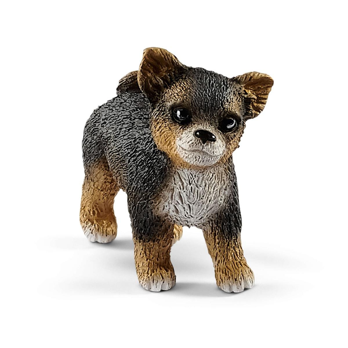 Eine Chihuahua-Hundefigur, braun und schwarz, blickt in die Kamera.