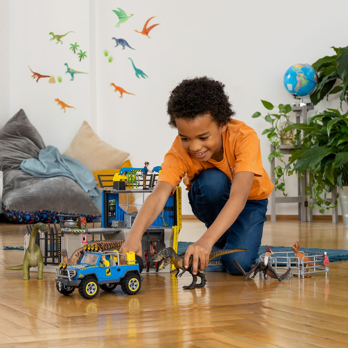 Junge spielt mit Dinosaurier-Spielzeug. Blauer Truck, Dino-Gehege und Kinderzimmer-Hintergrund.