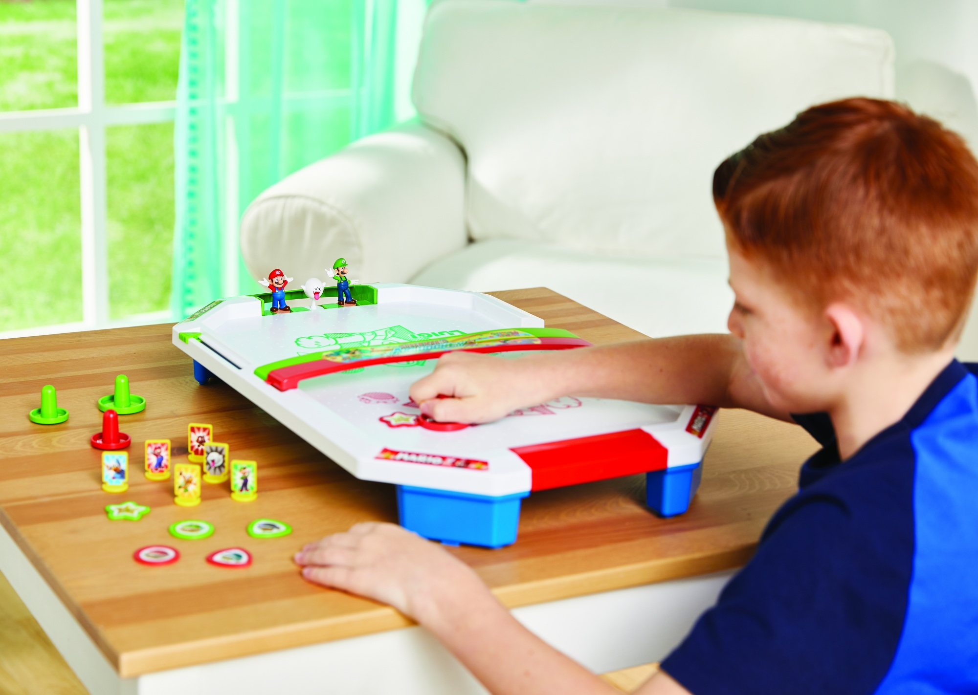 Boy playing a Mario themed game. Mario figures and a white game board are visible.
