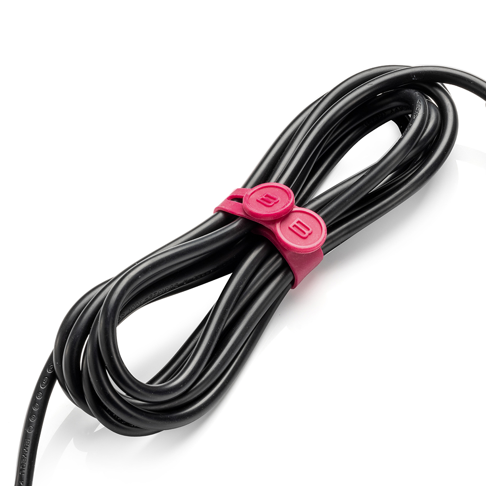 Zwarte stroomkabel gewikkeld en vastgezet met een magenta kabelbinder.