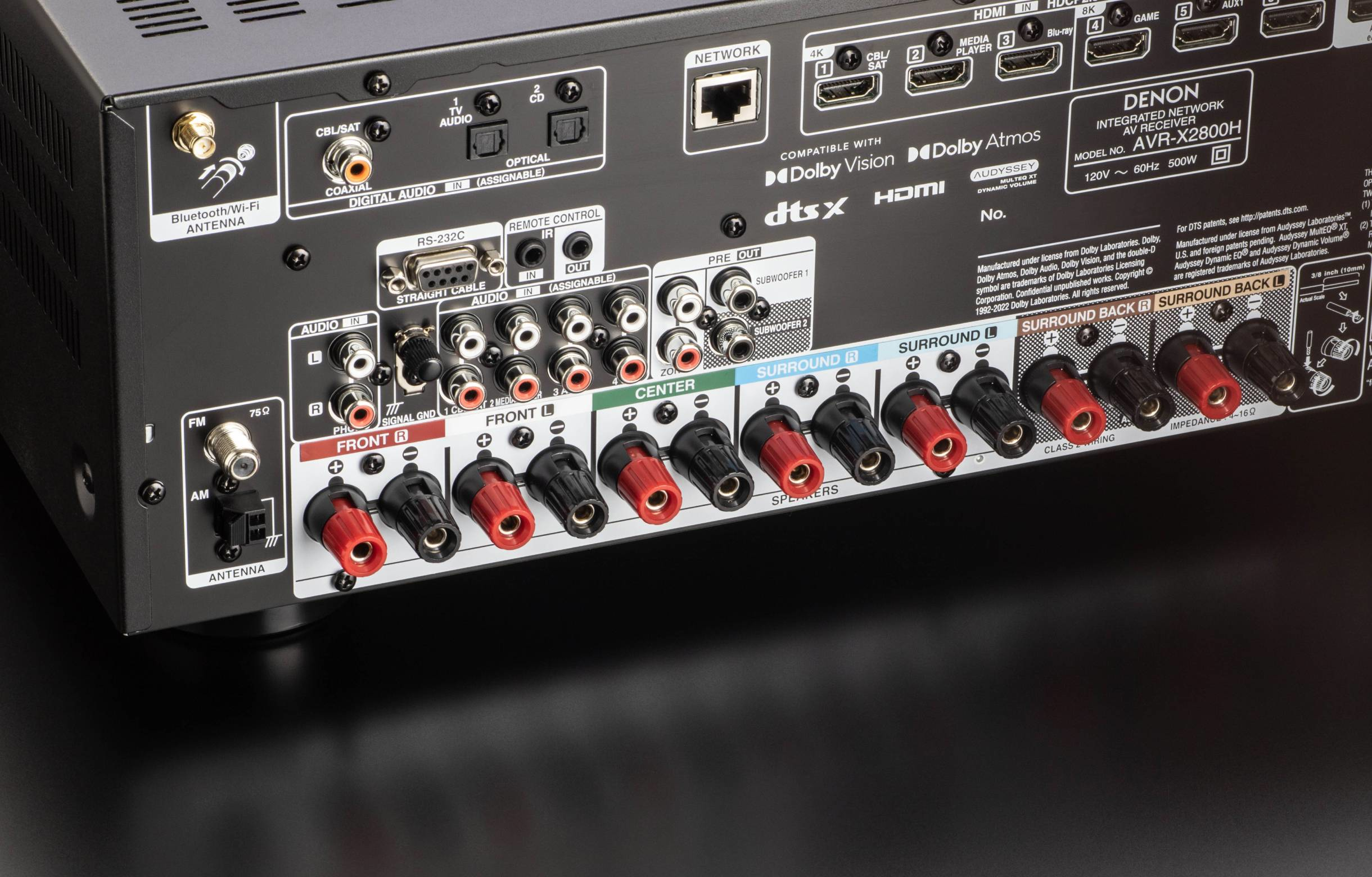 La parte trasera de un receptor Denon. Tiene muchos puertos, incluyendo terminales de altavoces y puertos de red.