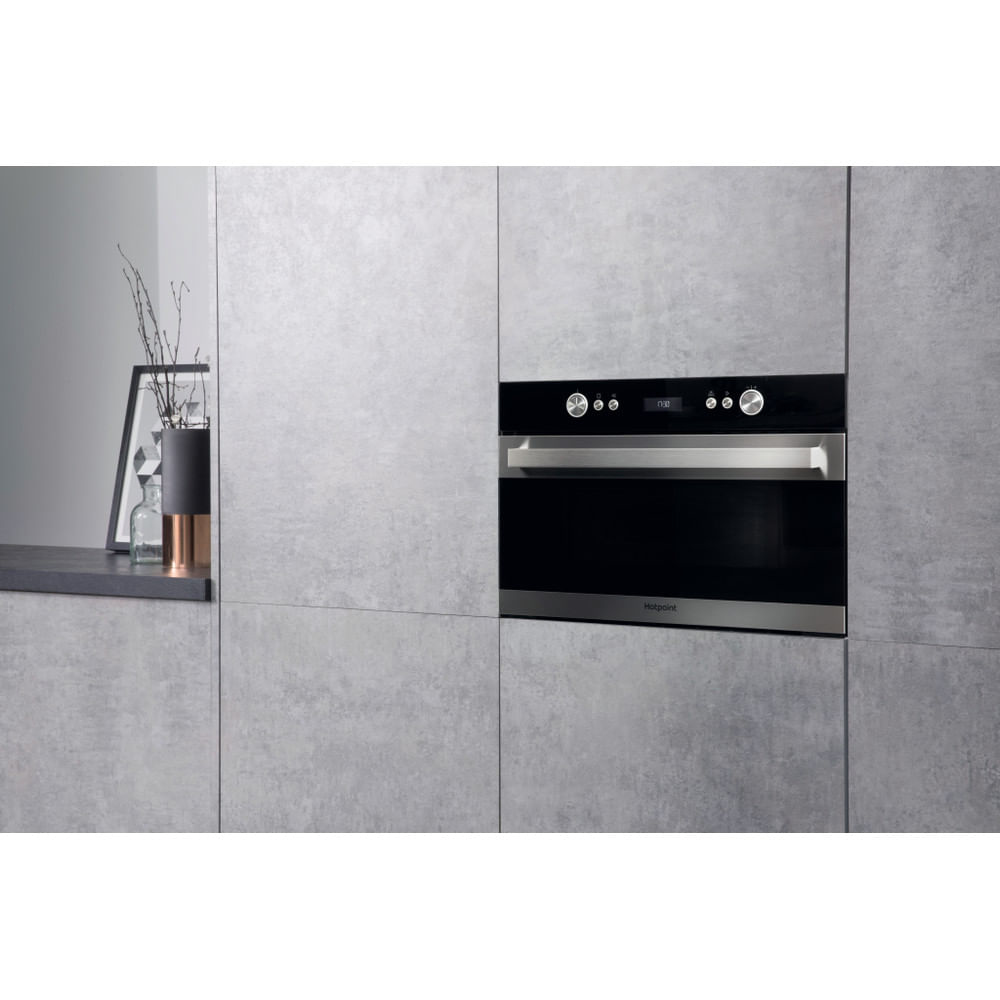 Forno nero da incasso in una cucina. È circondato da armadietti grigi e ha un display digitale.