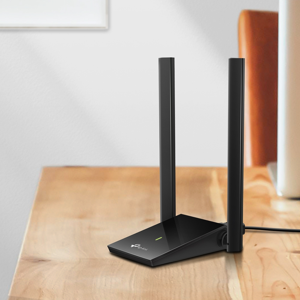 Répéteur Wi-Fi TP-Link noir sur une table en bois avec deux antennes.