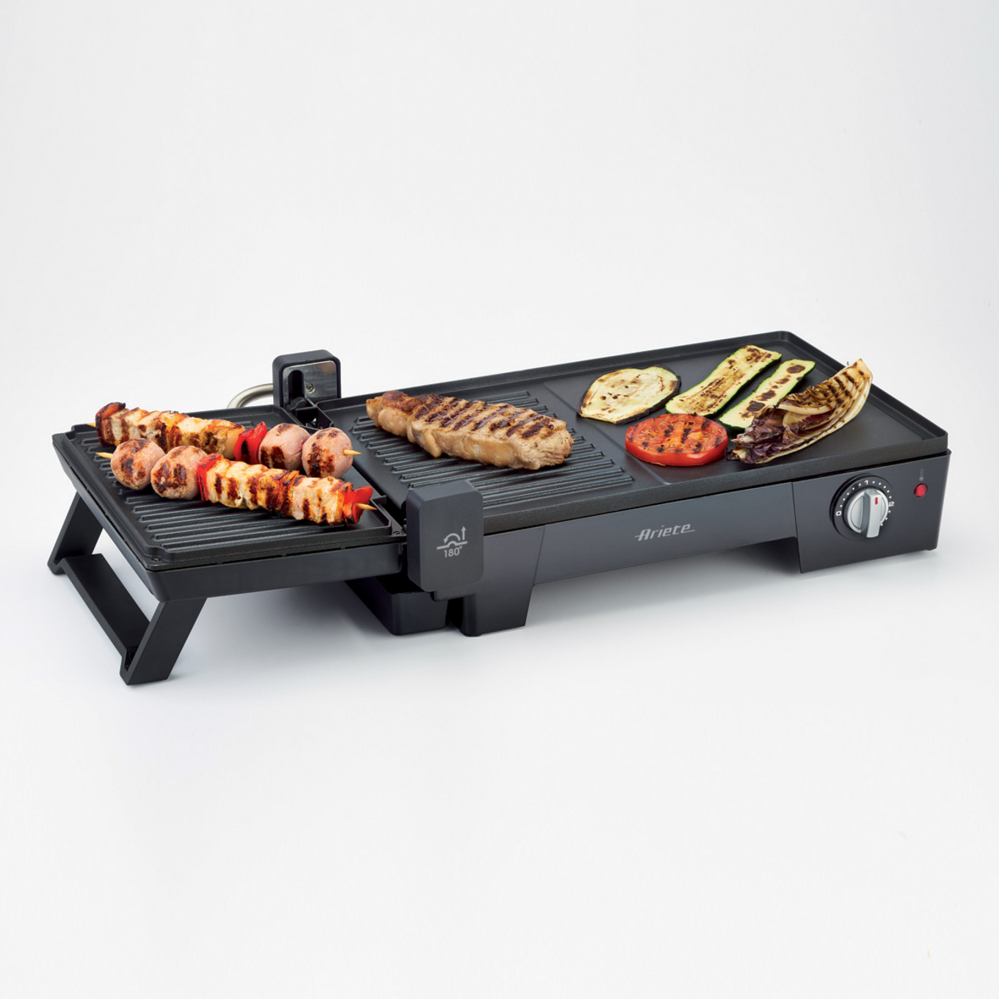 Electric grill with various grilled food on it. Steak, veggies, and kebabs.