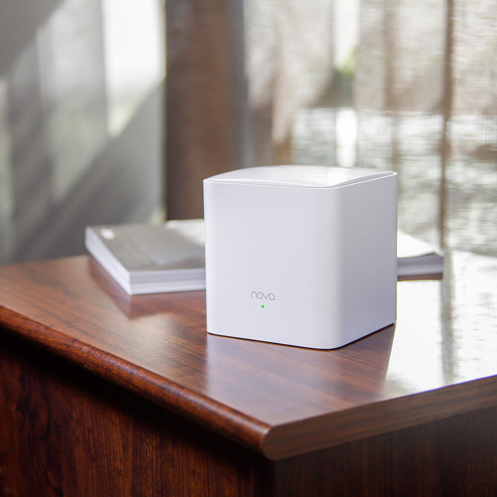 Biały router bezprzewodowy na drewnianym stole, z książką obok.