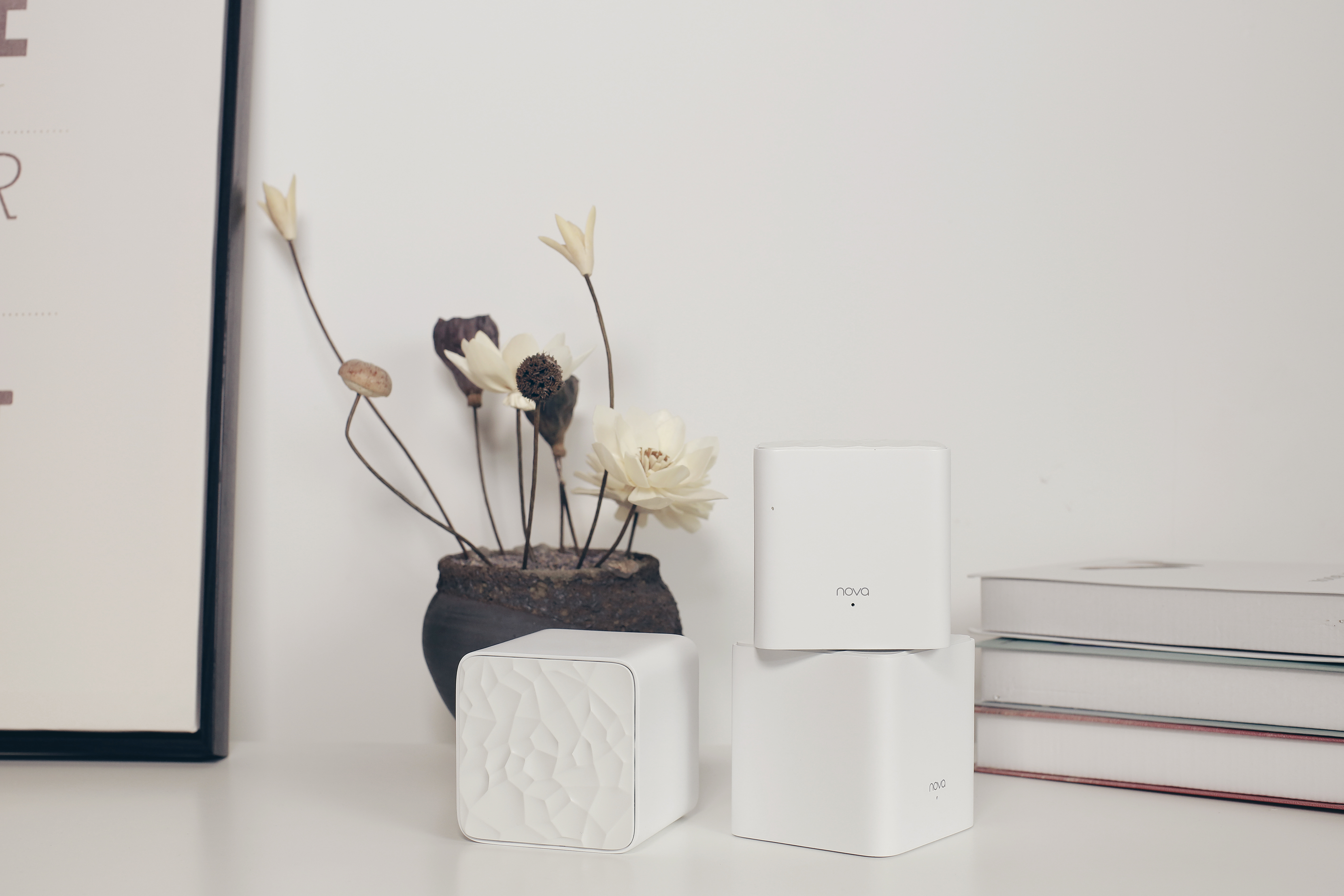 Dispositivi modem bianchi e vaso con fiori su tavolo bianco, con cornice.
