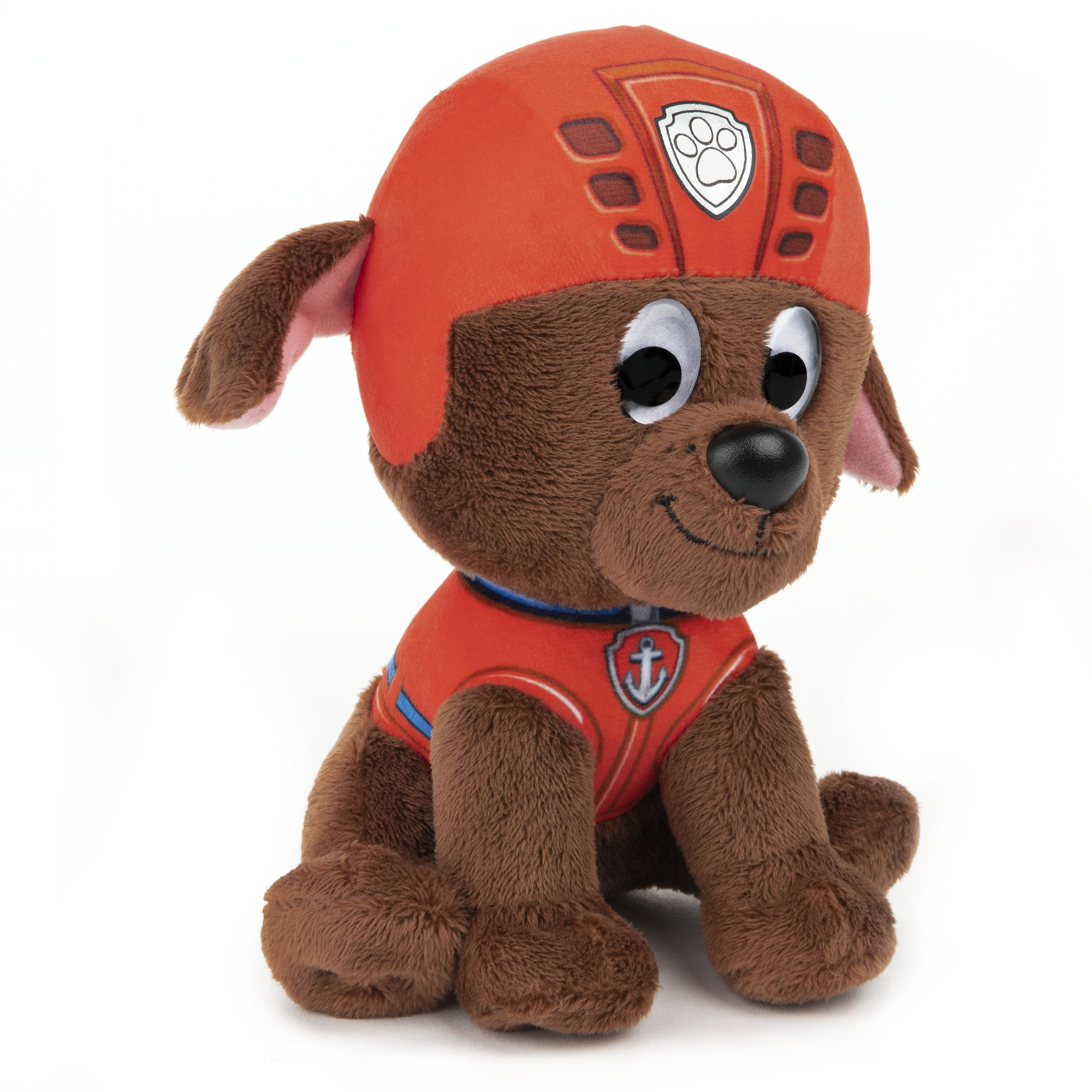 Brauner Paw Patrol Spielzeughund mit orangem Helm und Weste, sitzend auf weißem Untergrund.