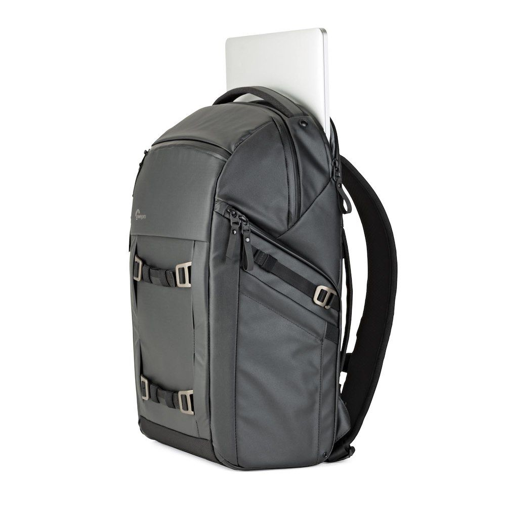 Dunkelgrauer Lowepro-Kamera-Rucksack. Ein silberner Laptop ist hinten. Weißer Hintergrund.