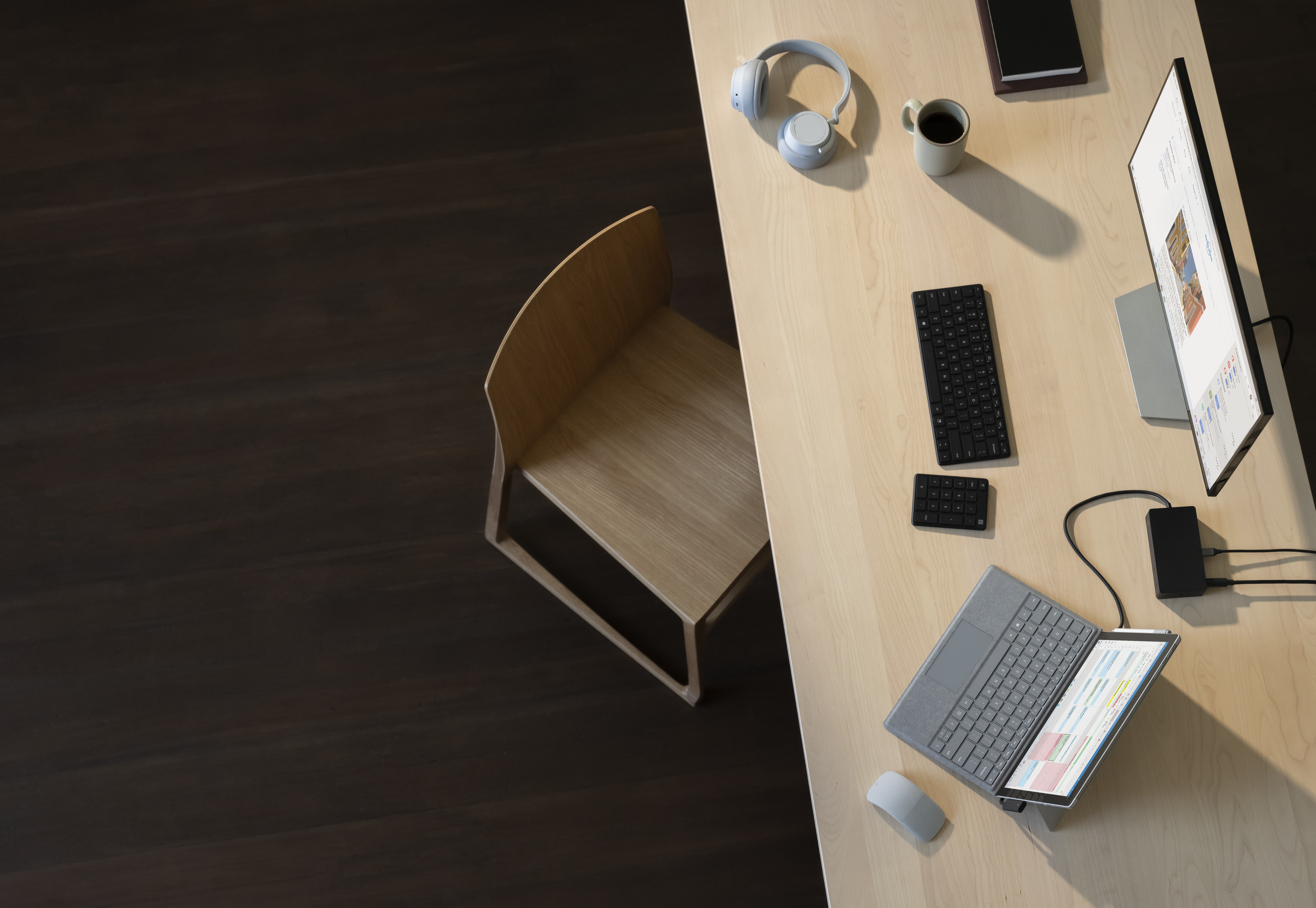 Widok z góry na ustawienie biurowe, w tym biurko, krzesło, monitor i klawiaturę.