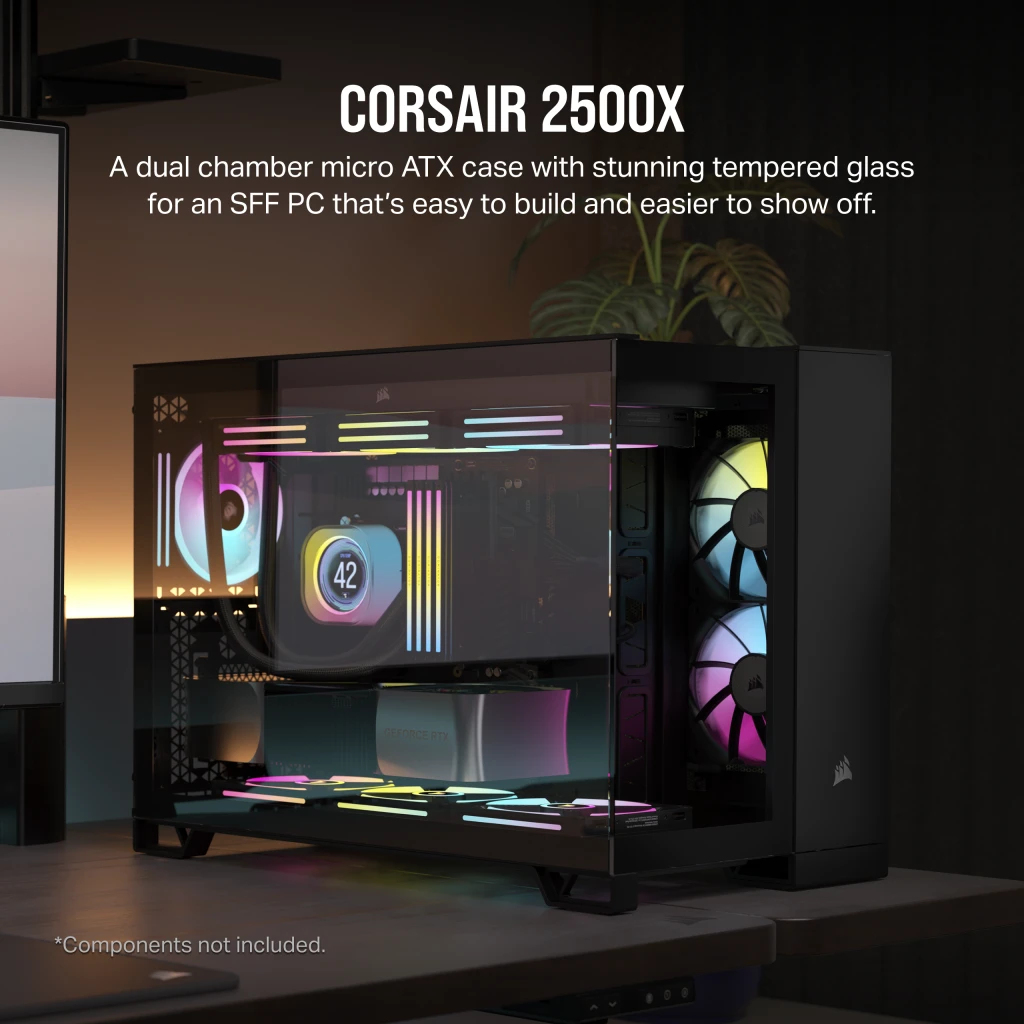 Obudowa Corsair 2500X z komponentami w środku, na biurku z monitorem i lampą.