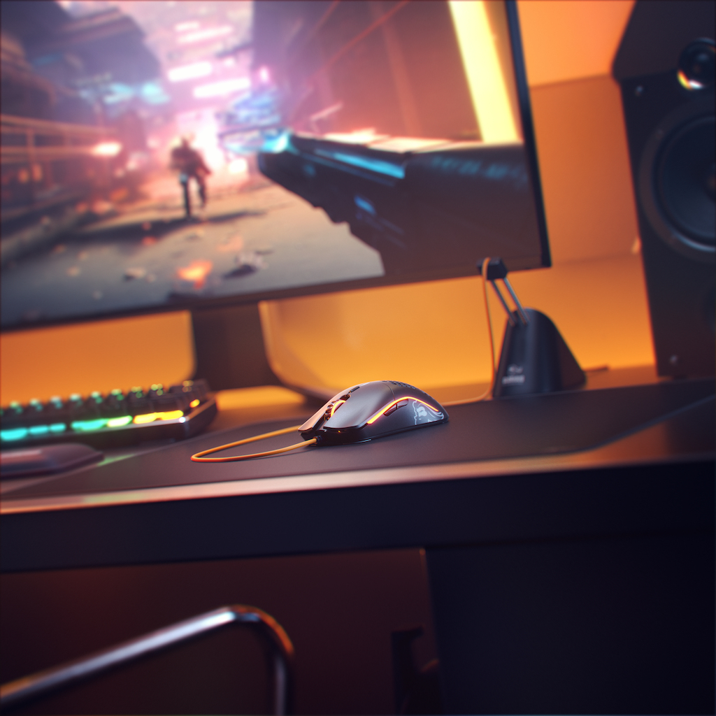 Gaming setup met muis op bureau. Monitor toont een game, speakers en toetsenbord zichtbaar.