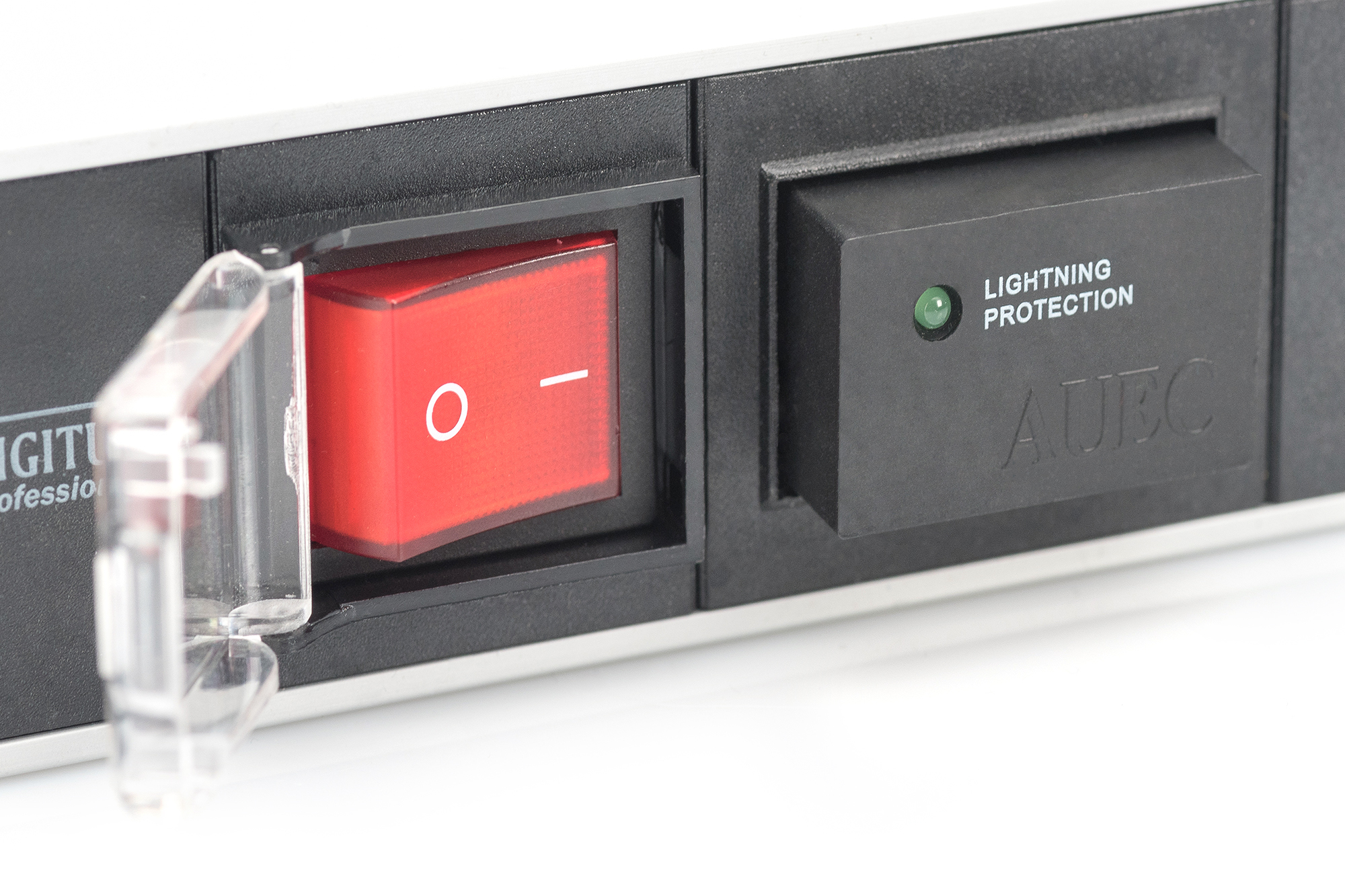 Zbliżenie listwy zasilającej z czerwonym włącznikiem, przezroczystą osłoną i czarnym włącznikiem ochrony przeciwprzepięciowej.