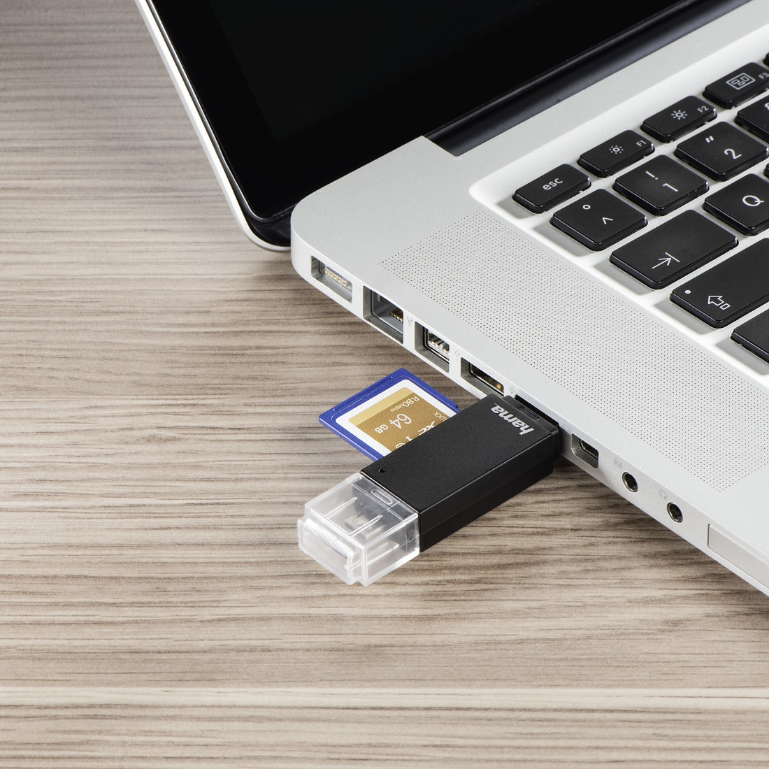 Laptop z adapterem USB i kartą pamięci włożoną do laptopa.