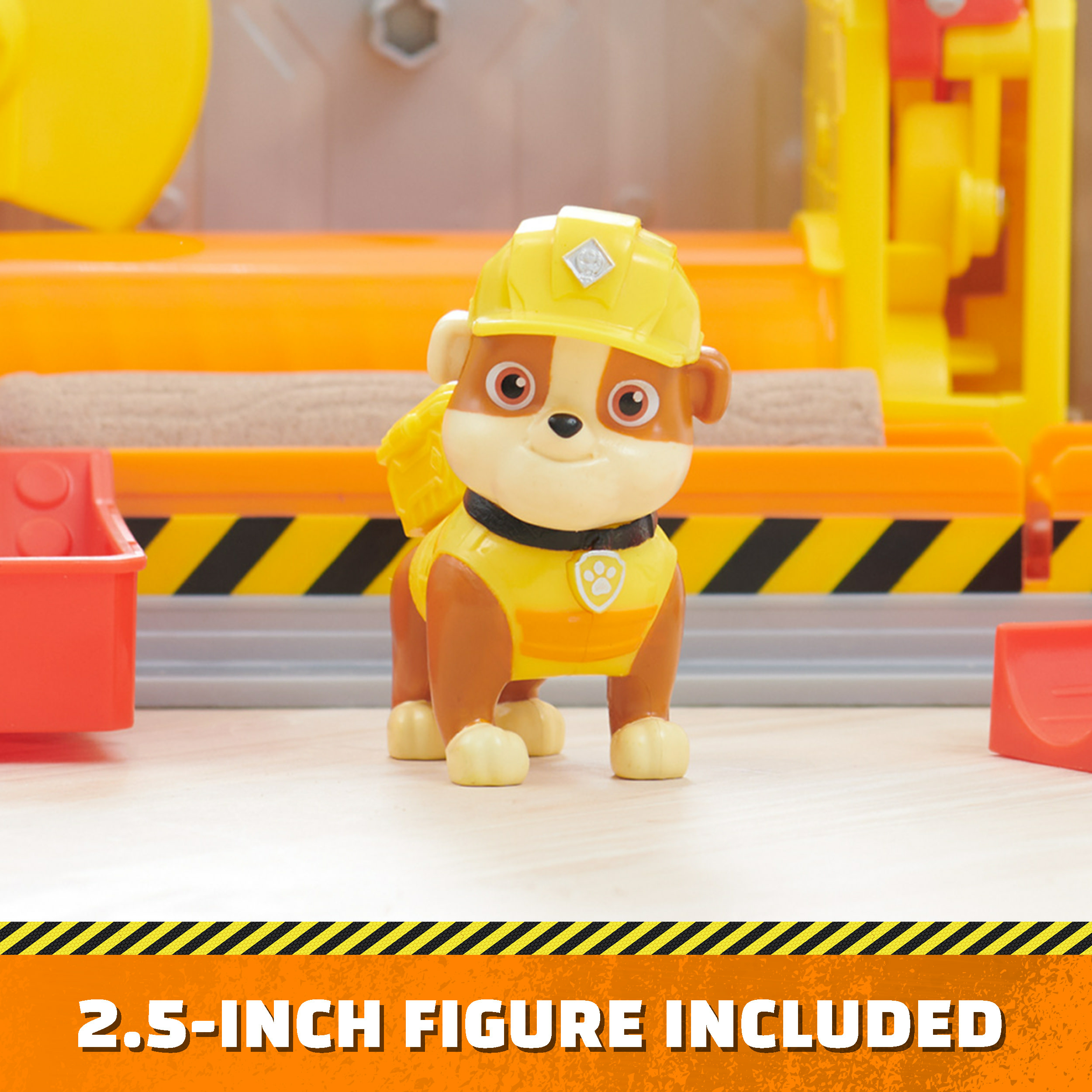 Ein gelbes Hundespielzeug in einer Baustelle mit gelben und orangen Elementen und einer Figur.