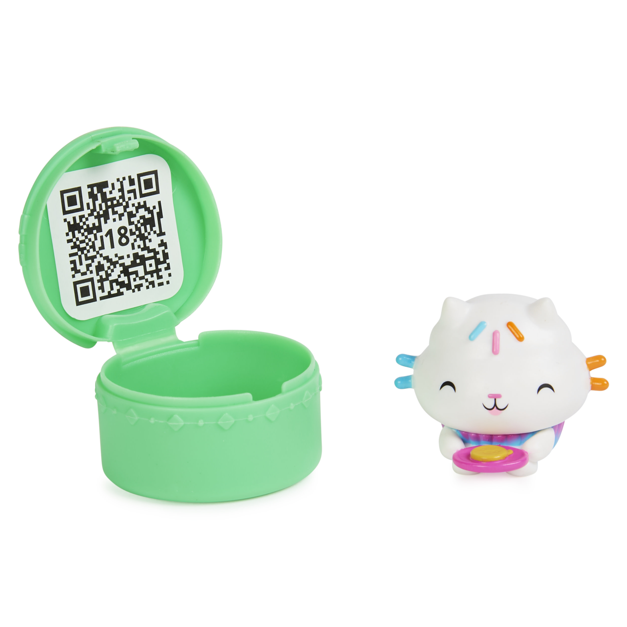 Eine kleine Spielzeugkatze mit Leckerli, neben einem geöffneten grünen Behälter mit QR-Code.