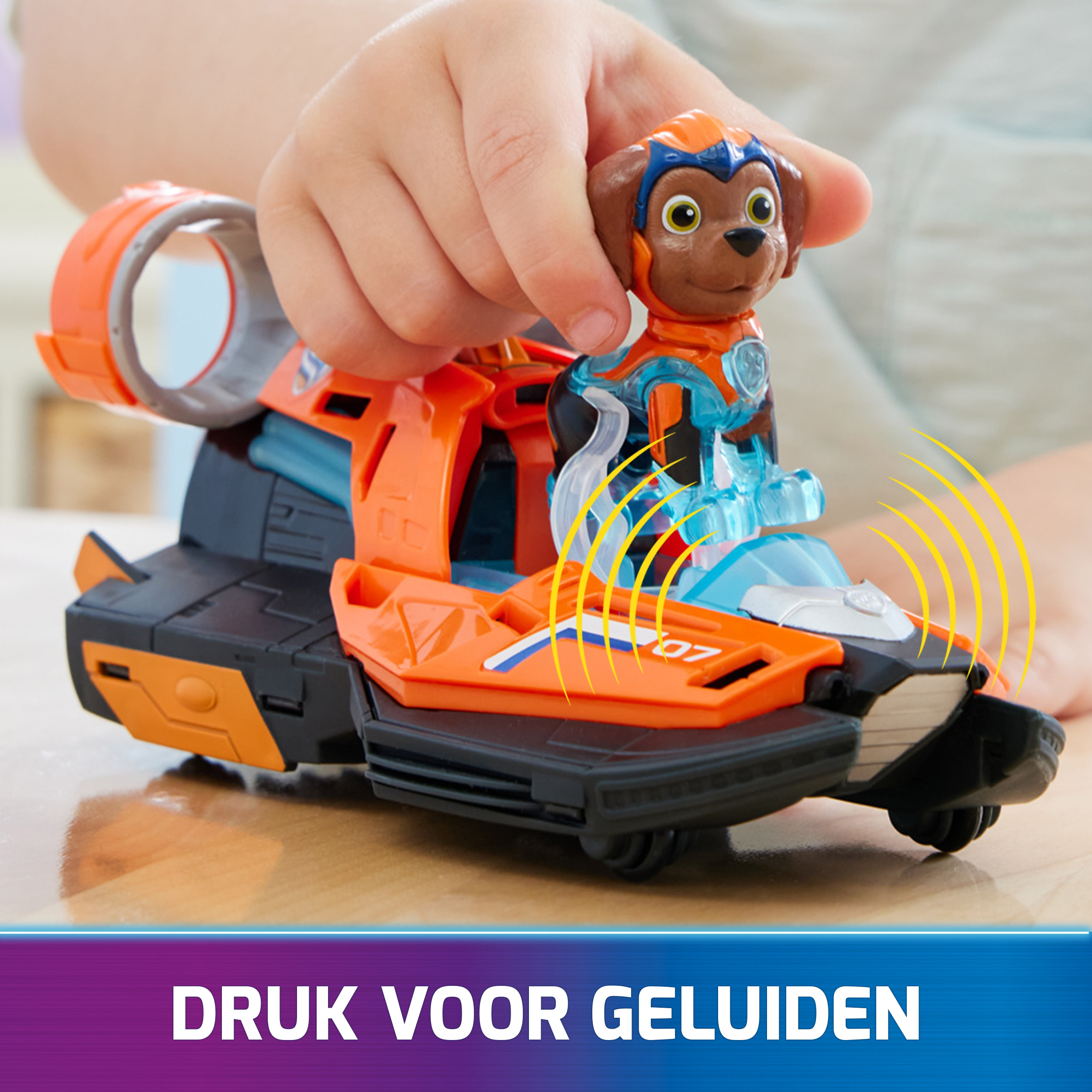 Kinderhand spielt mit einem Spielzeugfahrzeug mit einer Hundefigur darauf.