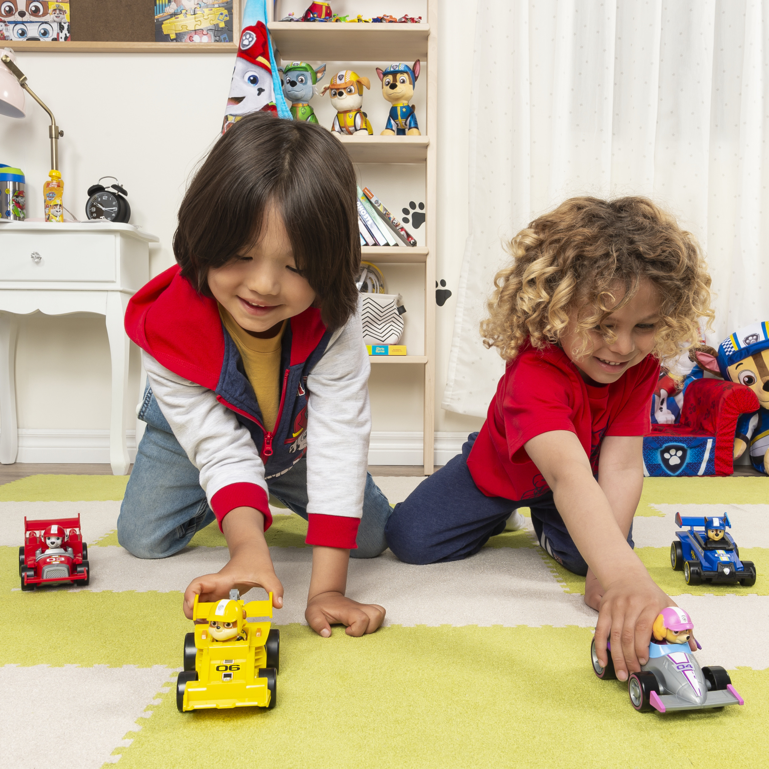 Twee kinderen spelen met speelgoedauto's op een groen-witte geblokte vloer.