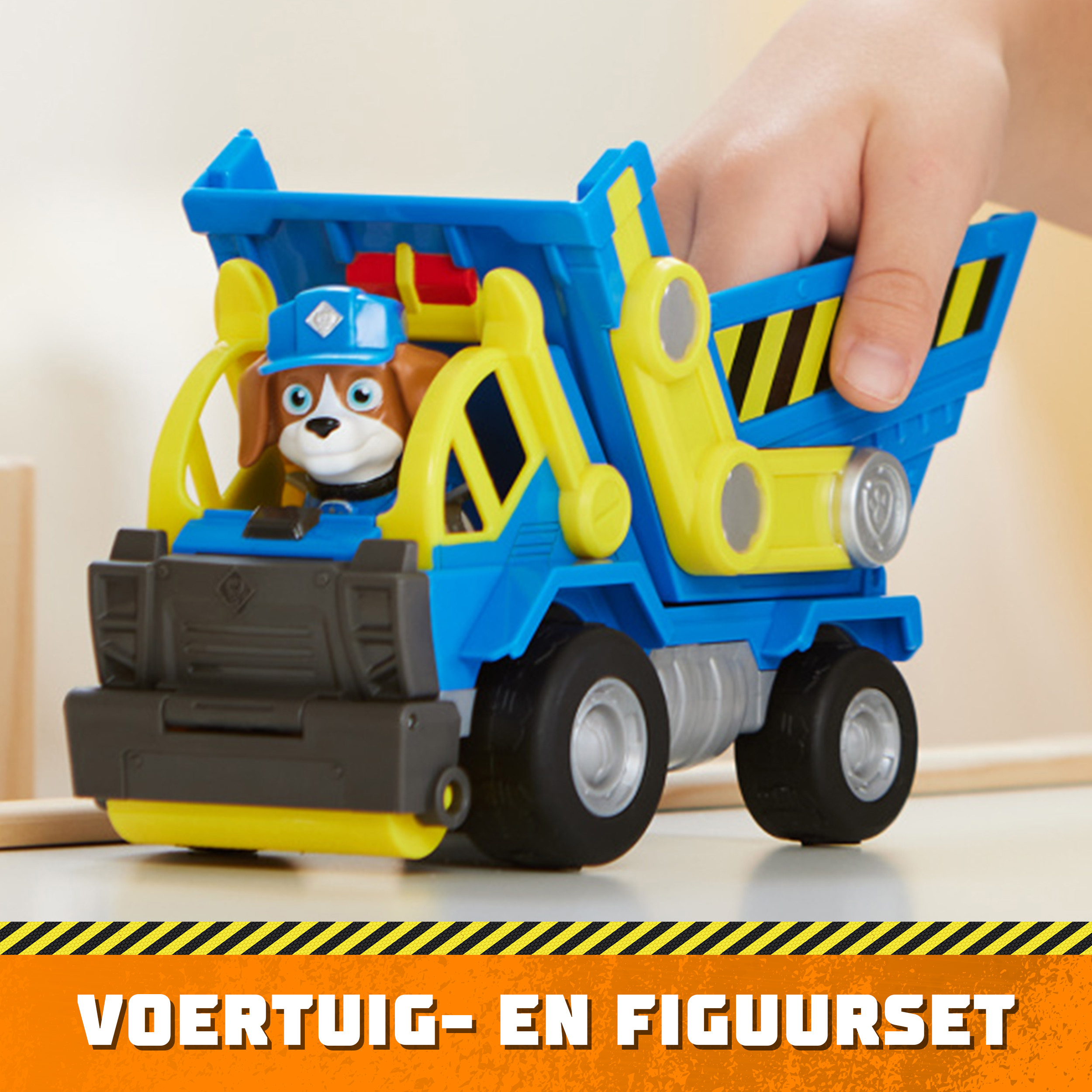 Die Hand eines Kindes hält einen blau-gelben Spielzeug-LKW mit einer Paw Patrol-Figur.