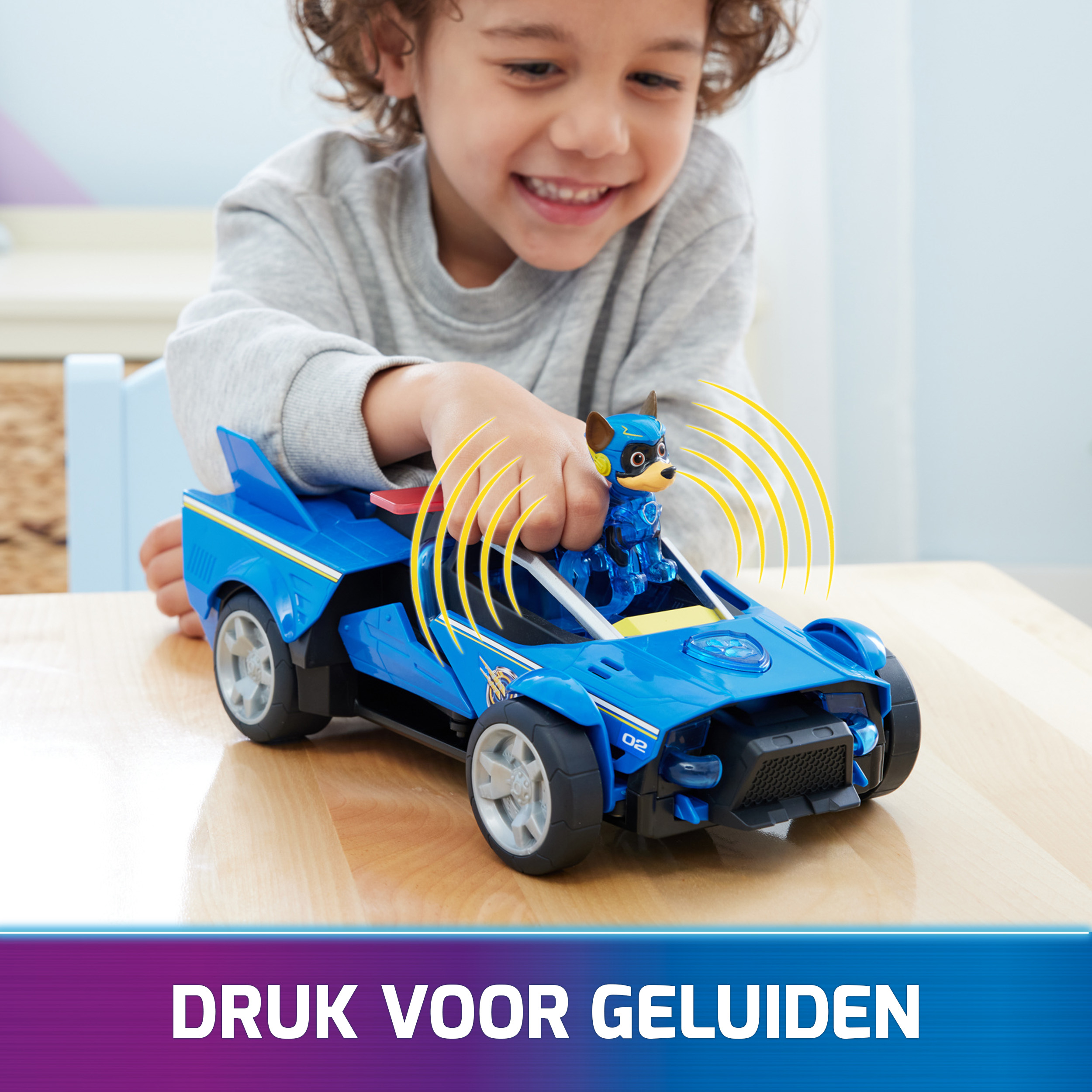 Niño jugando con un coche de juguete. El coche de juguete tiene luces y un personaje dentro.